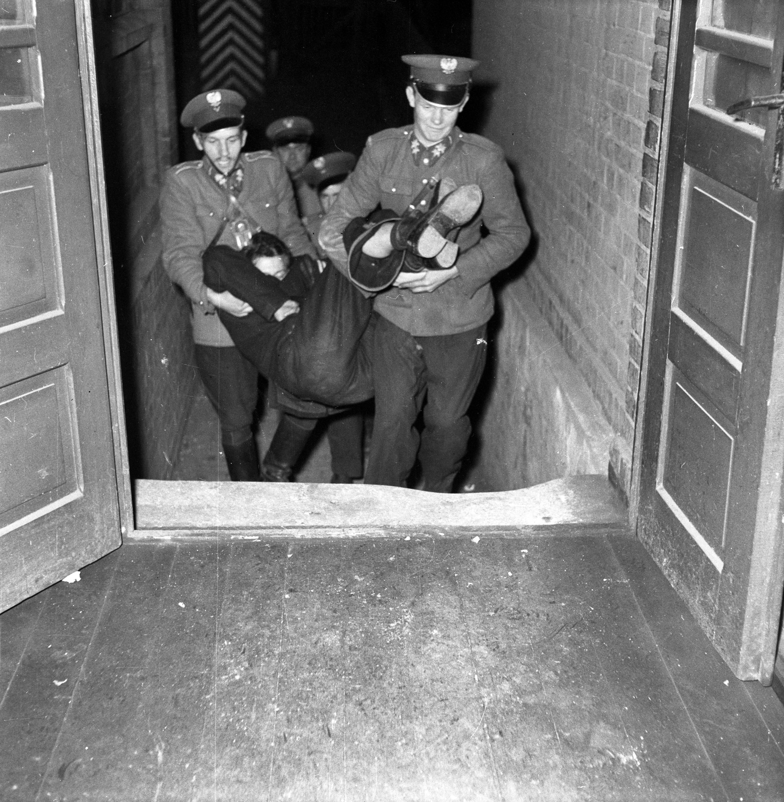 Milicjanci niosą pijanego mężczyznę na komendę, Katowice, październik 1957 r.