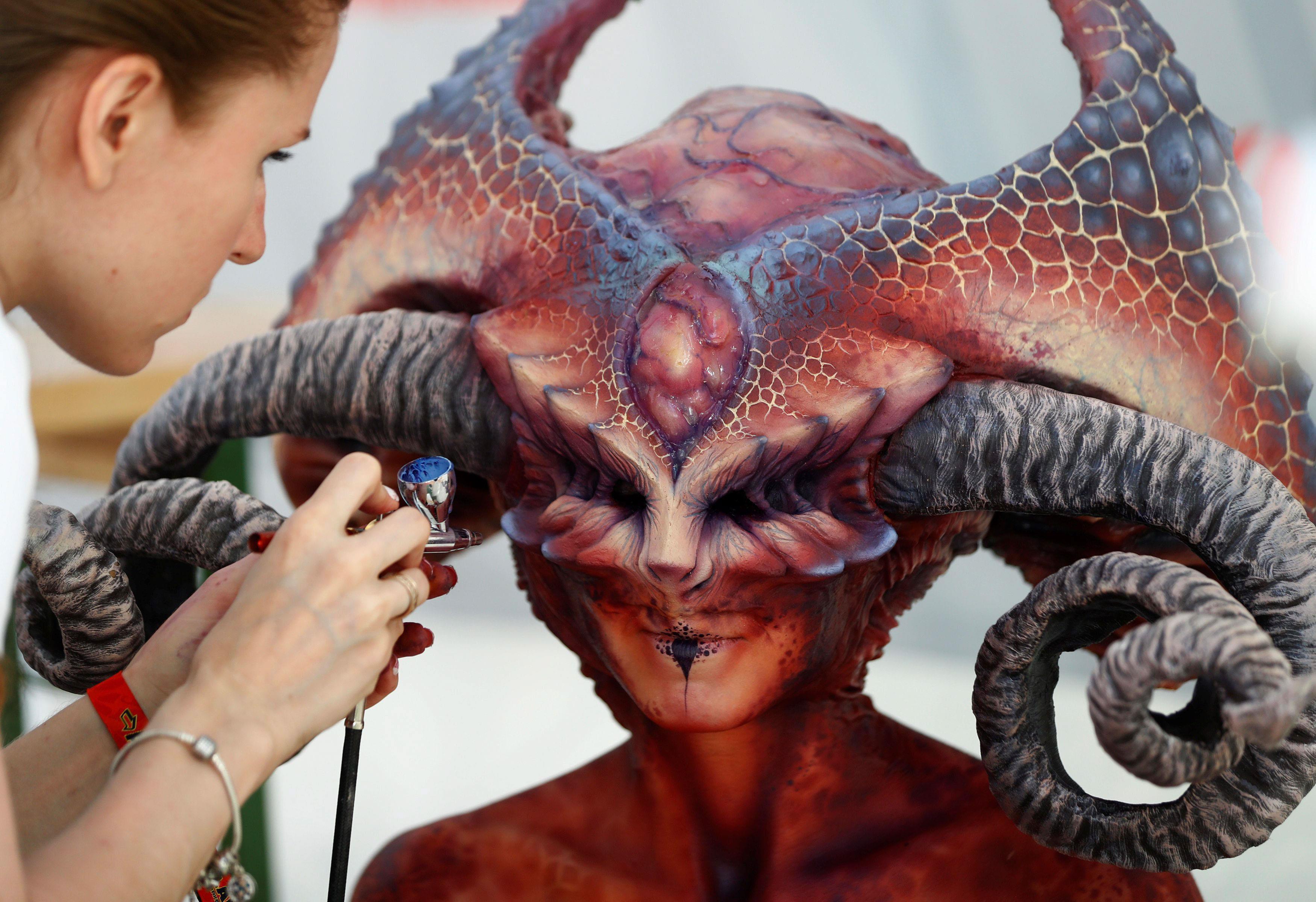 An artist airbrushes a model during the 