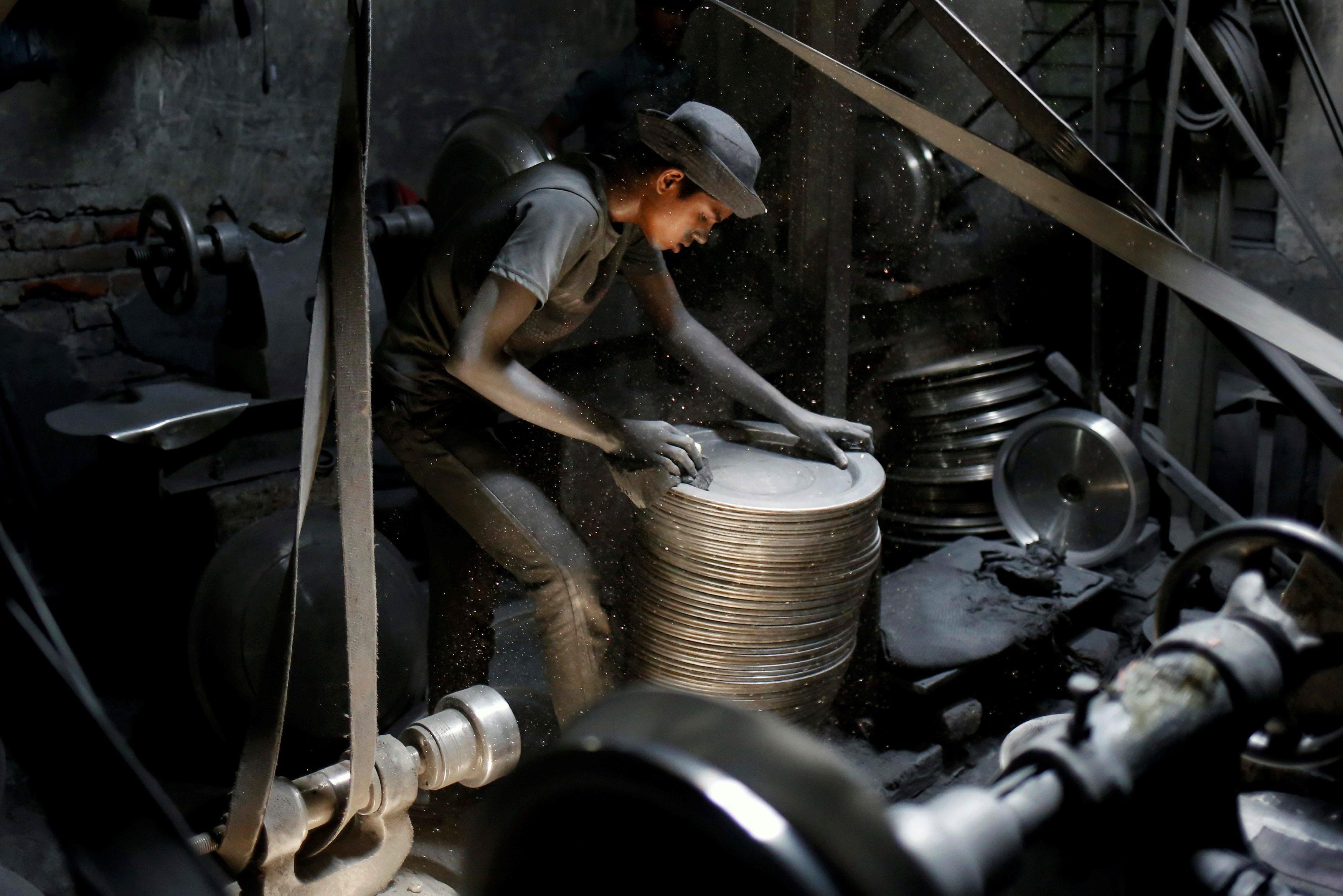 A boy works at a aluminum utensils factory in Dhaka