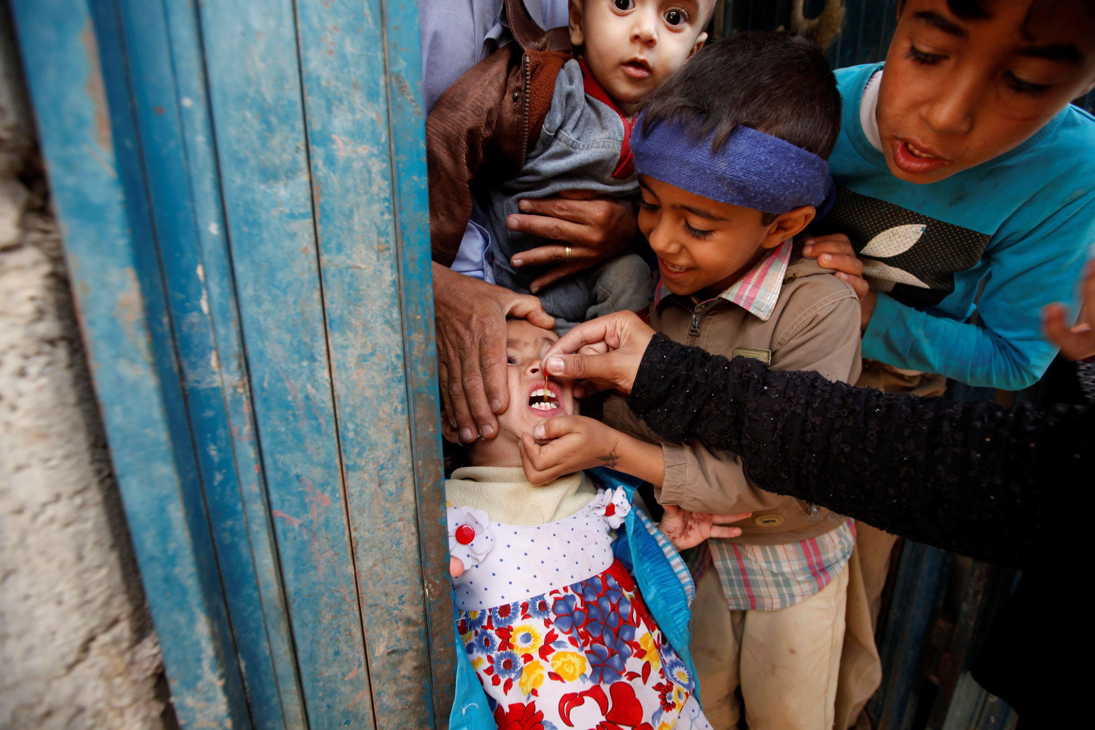 A girl receives polio vaccination drops during a house-to-house vaccination campaign in Yemen's capi