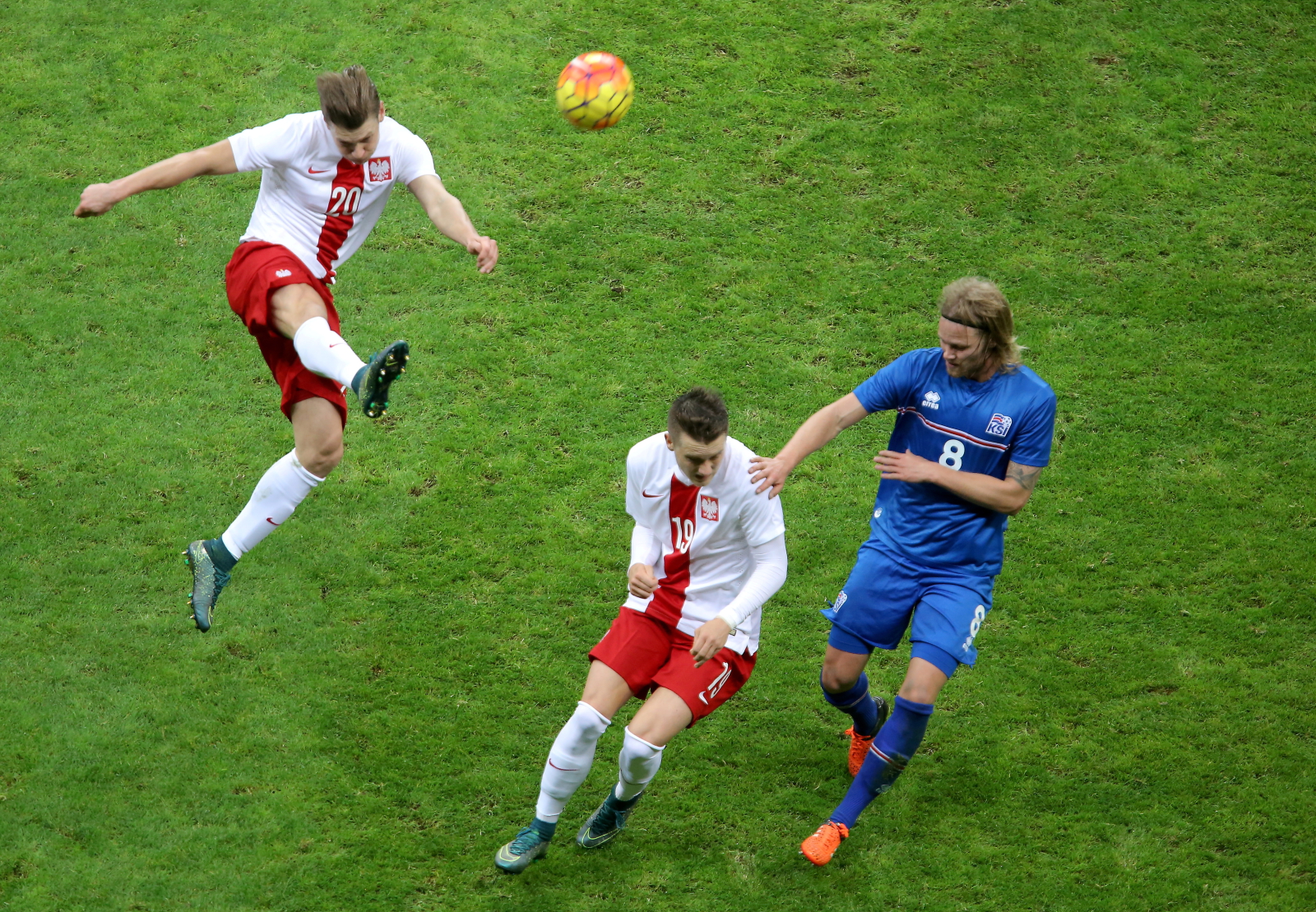 Łukasz Piszczek (L) wybija piłkę podczas meczu towarzyskiego z Islandią, 13 bm. w Warszawie. Niżej Piotr Zieliński (C) i Birkir Bjarnason (P)