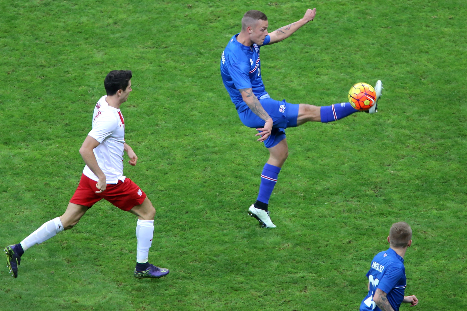 Polak Robert Lewandowski (L) walczy o piłkę z Islandczykiem Ragnarem Sigurdssonem (P) podczas meczu towarzyskiego w Warszawie