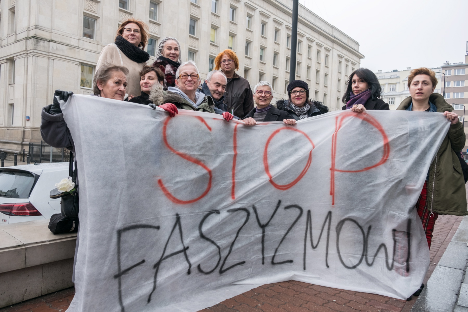 14 kobiet z mostu z adwokatem tuż po decyzji sądu nakazującego prokuraturze ponowne otworzenie dochodzenia w sprawie ataku i pobicia podczas Marszu Niepodległości w 2017 r., Warszawa, 13 lutego 2019 r.