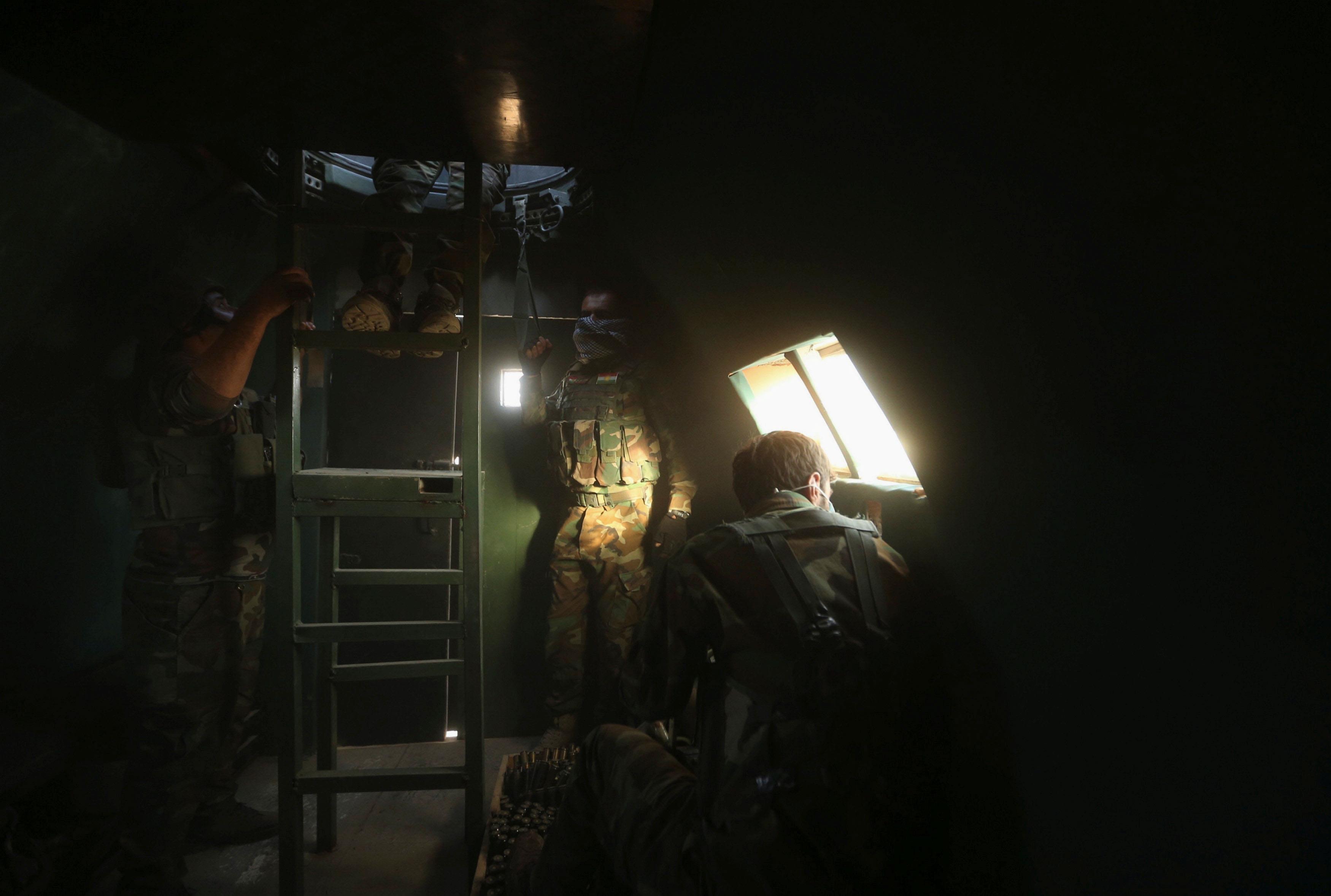 Members of the Peshmerga forces are seen inside a military vehicle north of Mosul, during an operati