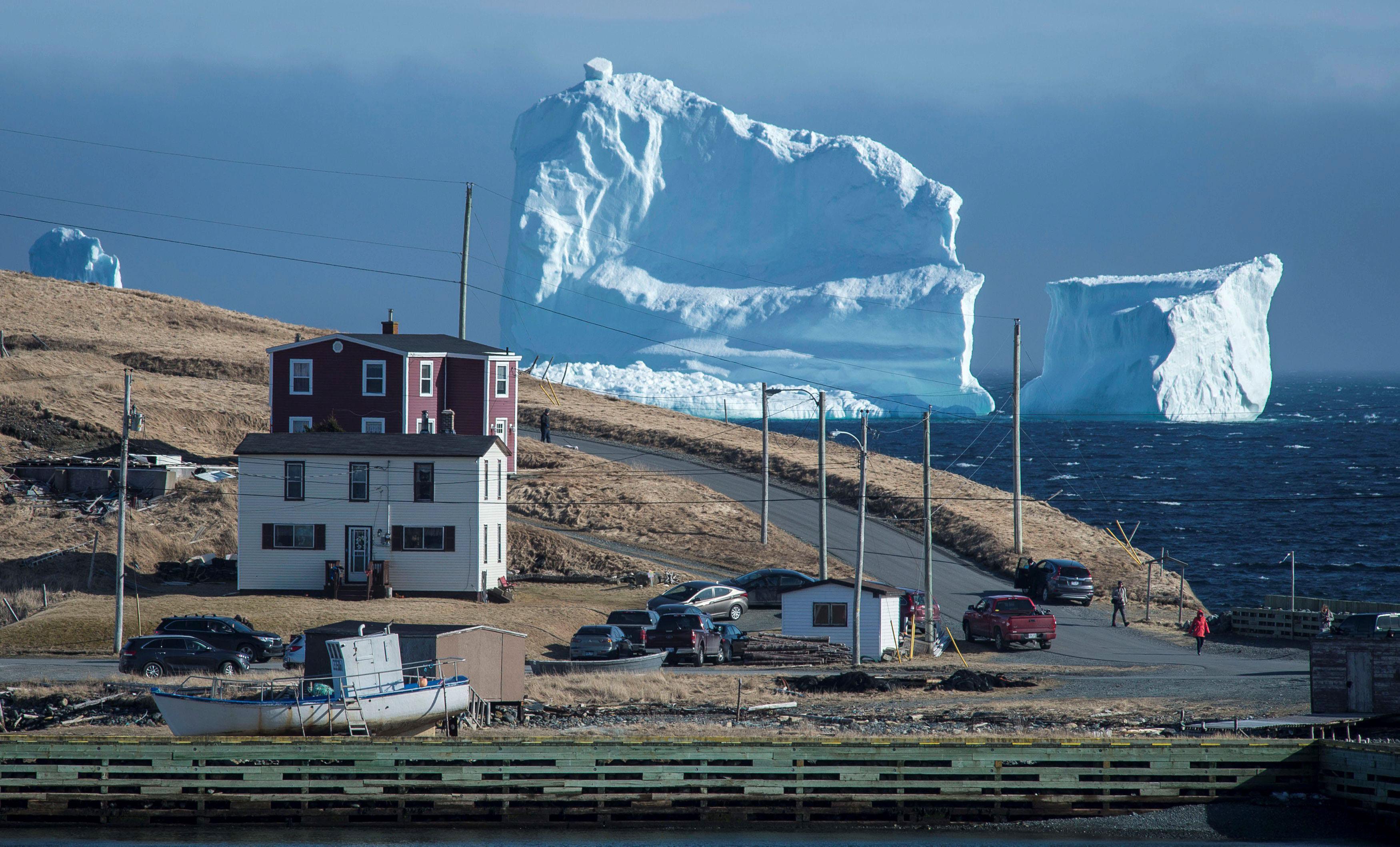 Residents view the first iceberg of the season as it passes the South Shore of Newfoundland