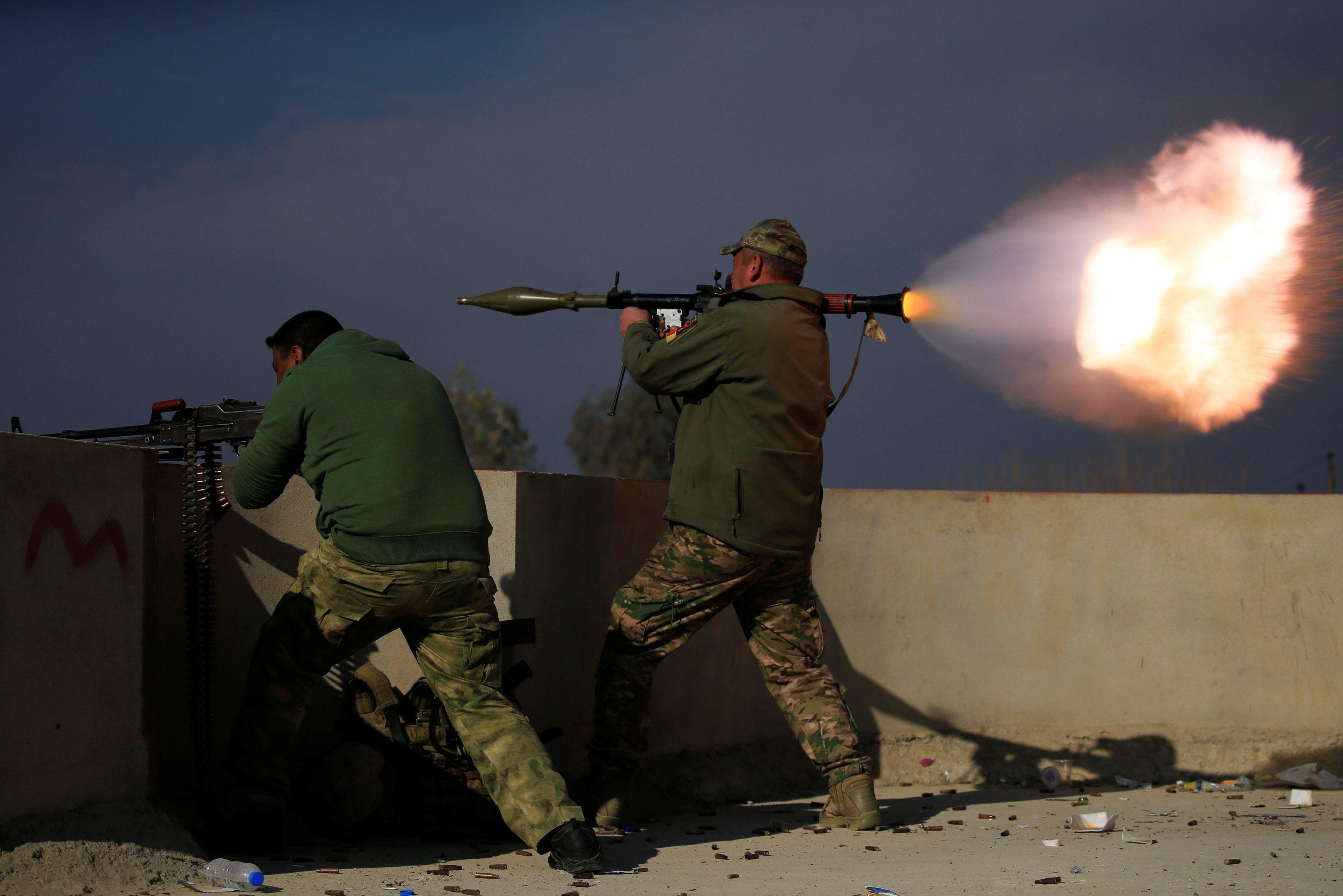 A member of Iraqi rapid response forces fire a rocket launcher during a battle with Islamic State mi