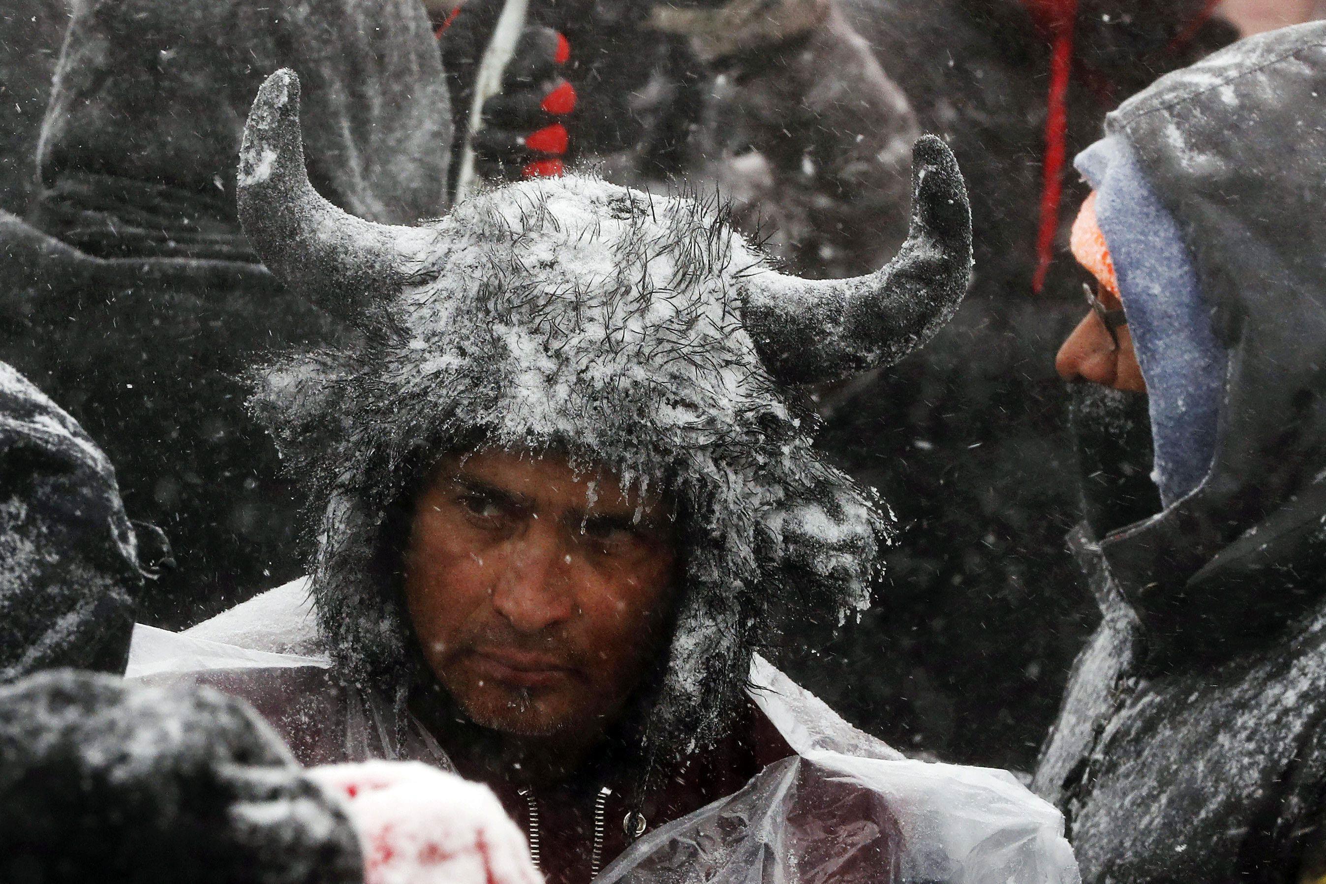 A Native American man stands in the snow during a march with veterans near Backwater Bridge just out