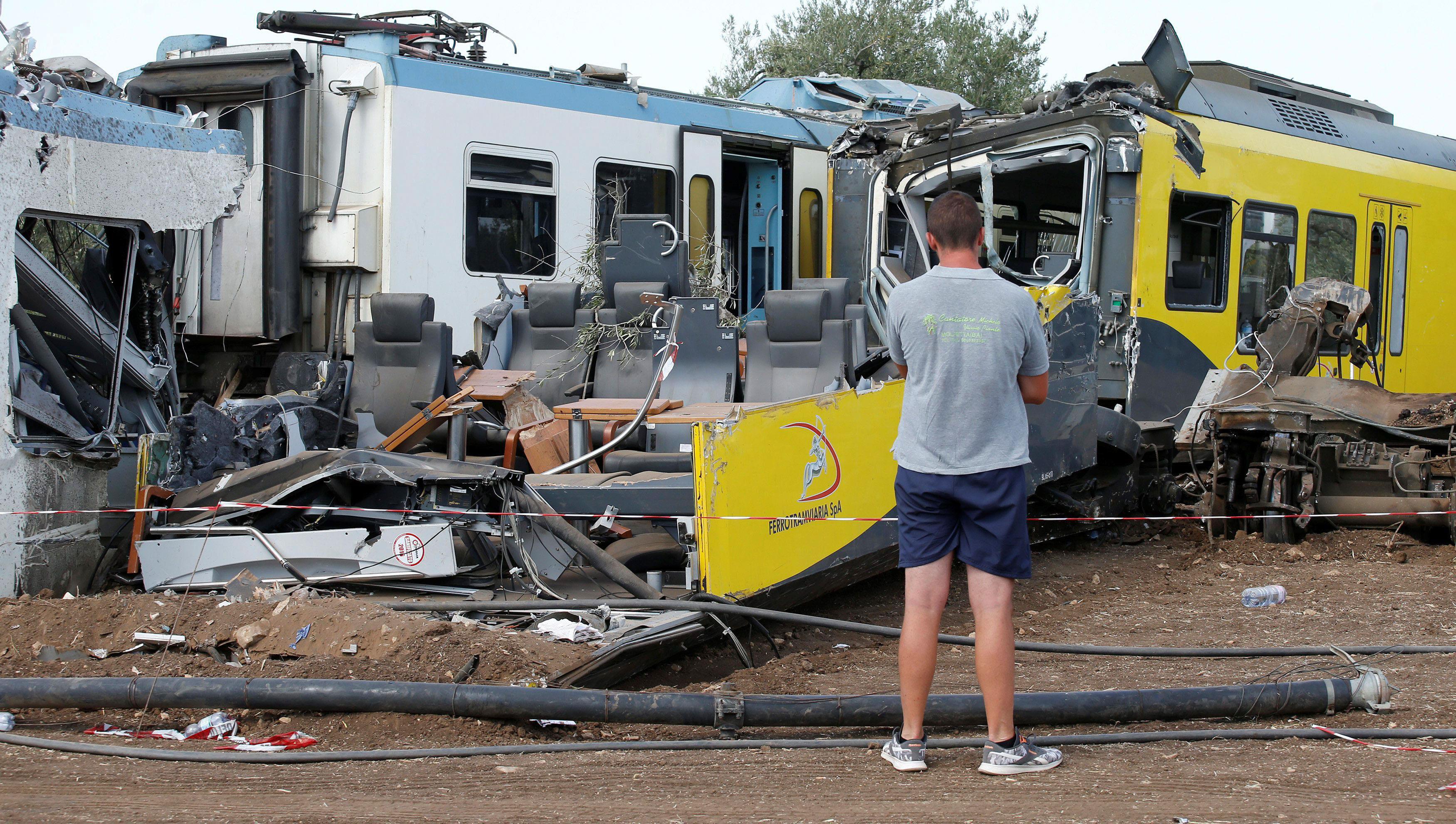 Workers are seen at the wreckage at the site where two passenger trains collided in the middle of an