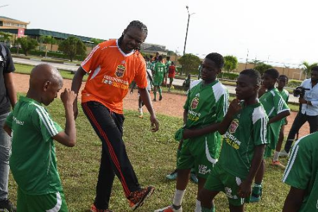 Footballer, Kanu Nwankwo working with the children during the camp.