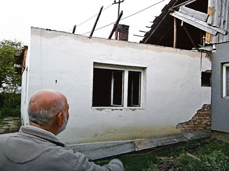 Ćake Šipčanin pokazuje kuću uništenu u  poplavama