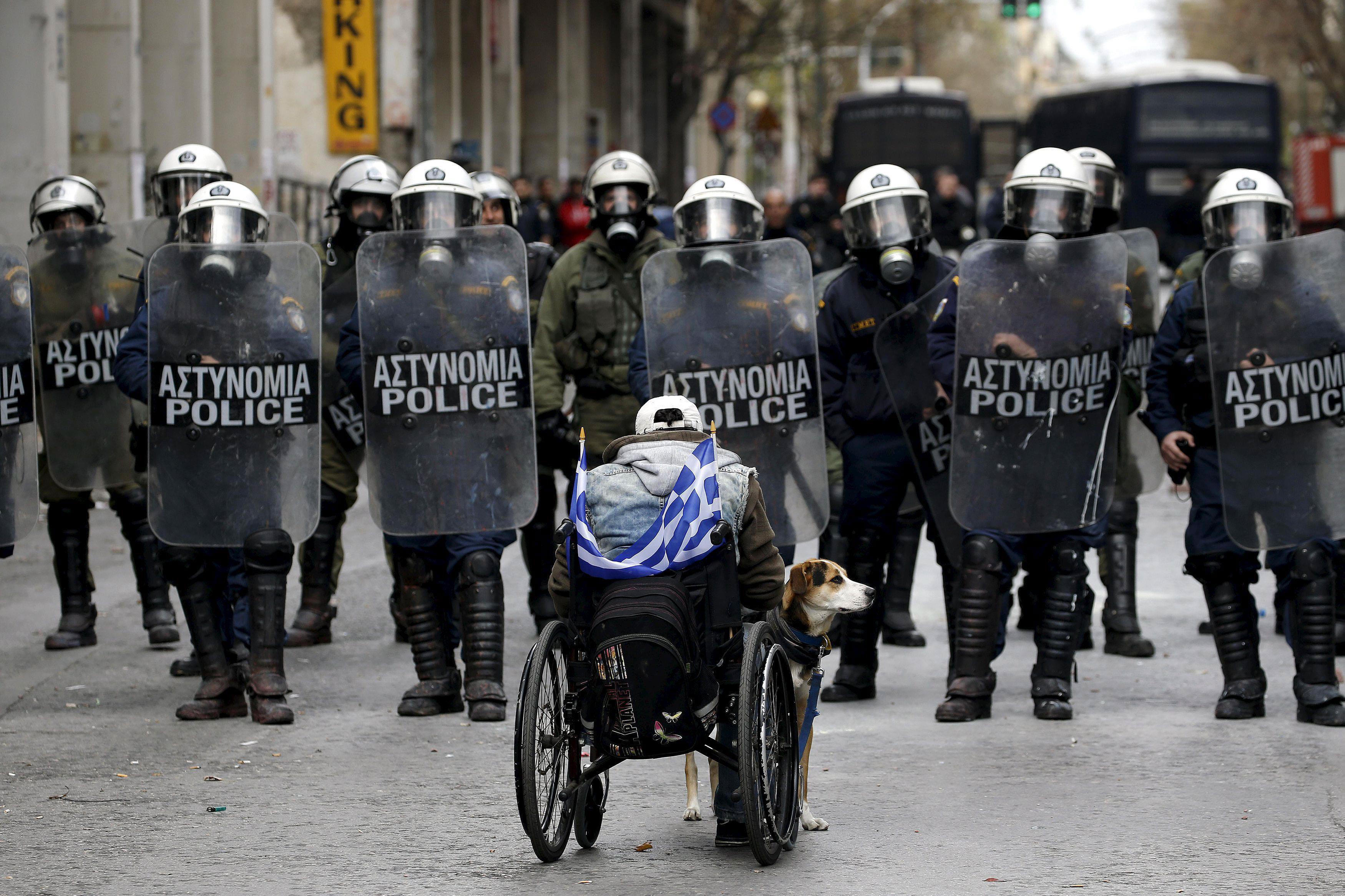 A handicapped protester and his dog face a riot police cordon outside the Agriculture ministry follo