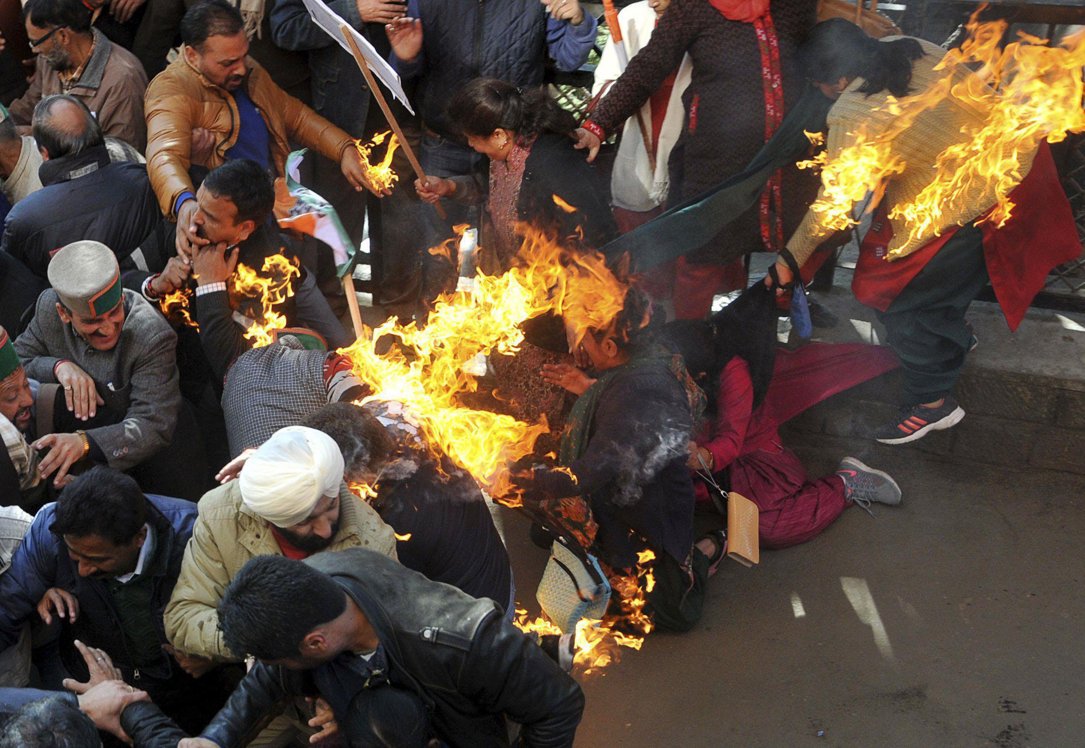 Activists from India's main opposition Congress party try to flee after their clothes caught fire wh