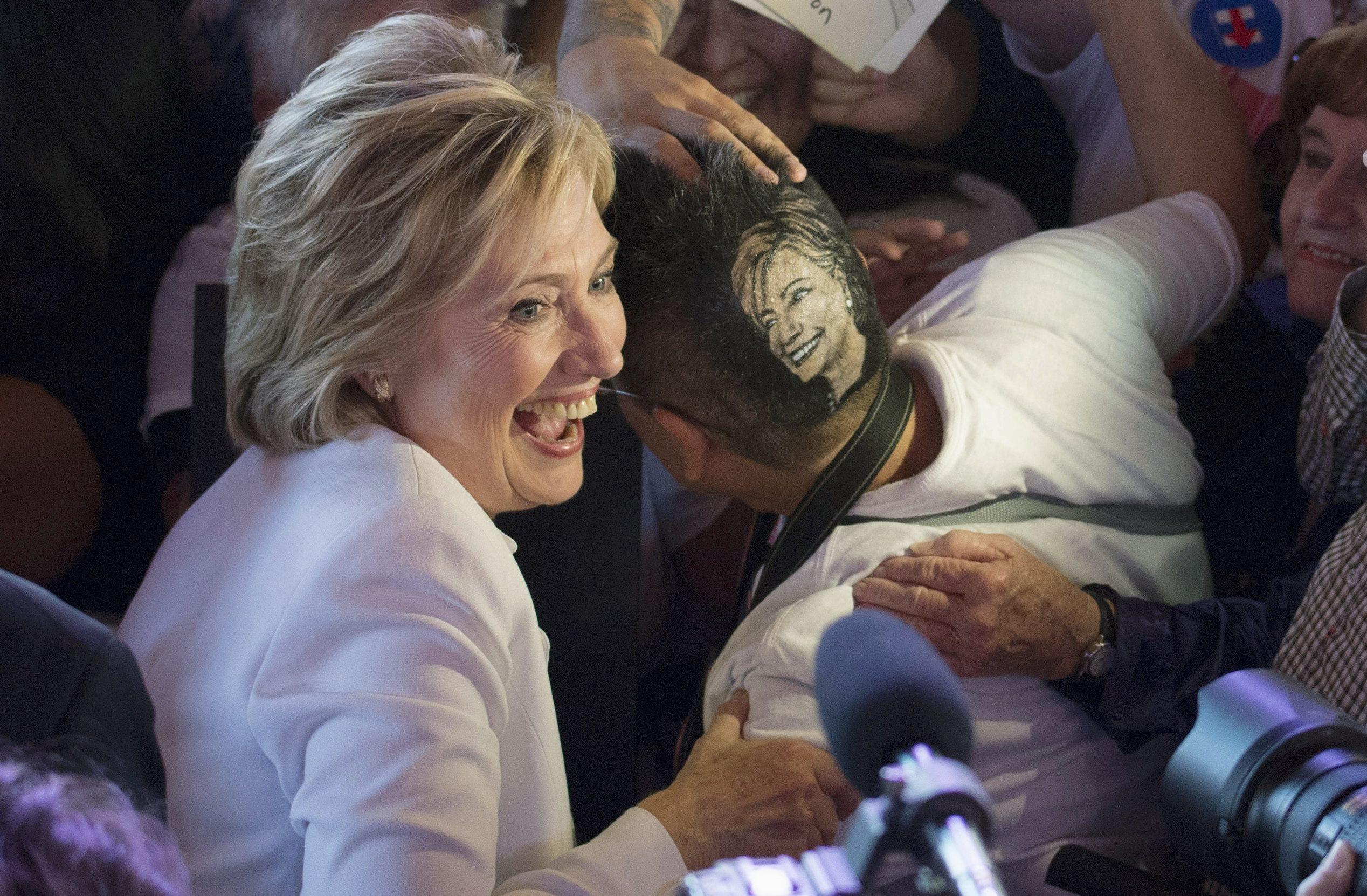 Democratic presidential candidate Clinton poses for a picture with supporter Monsivaiz who has her h