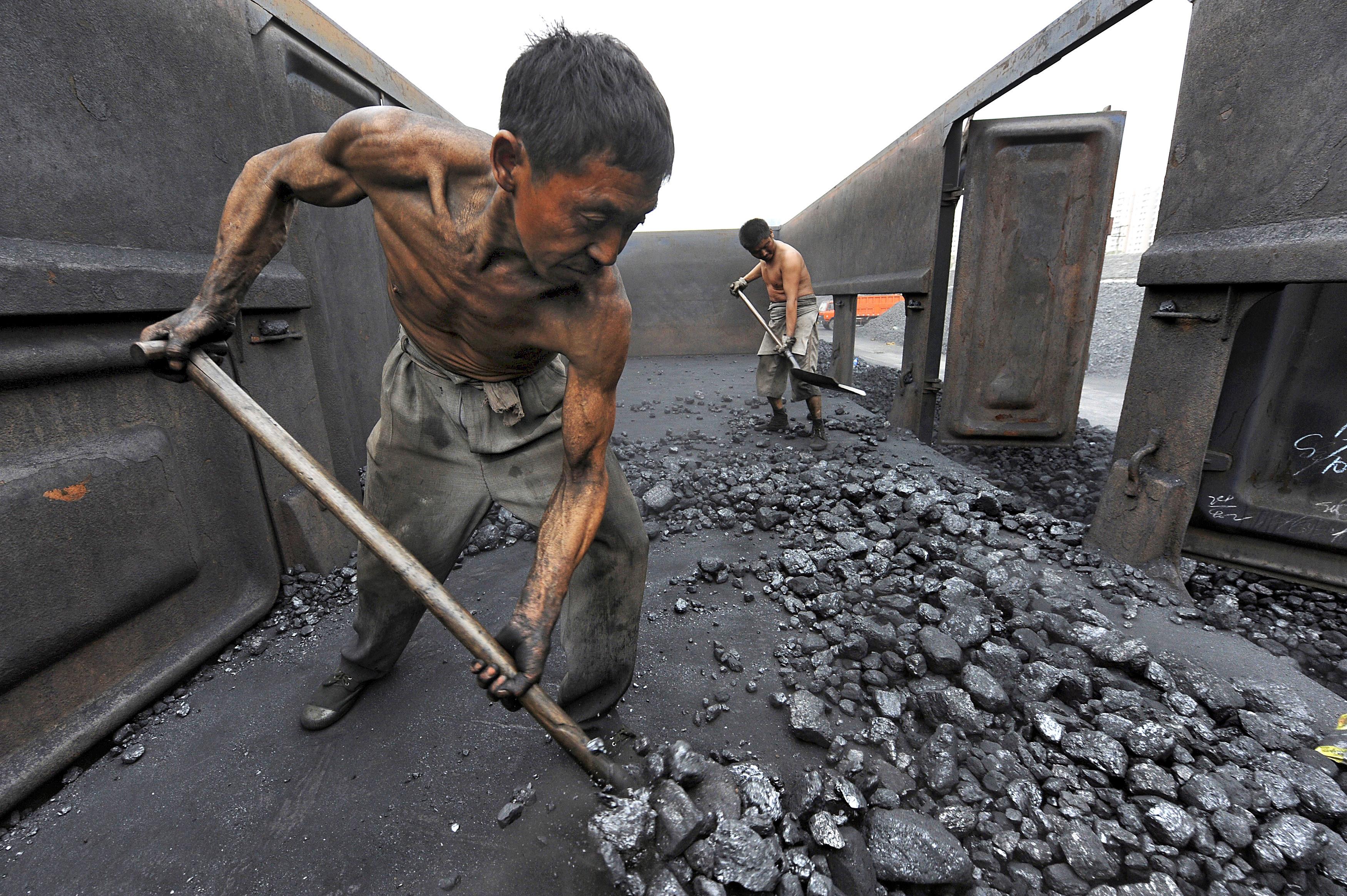 File photo of workers unloading coal at a storage site along a railway station in Hefei,