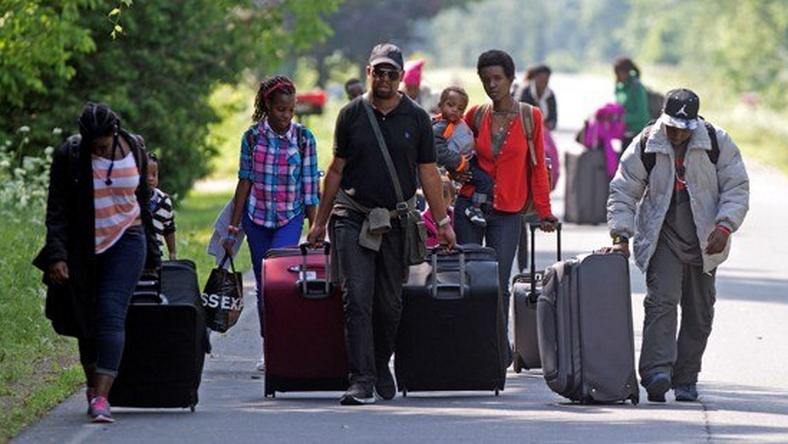 Asylum seekers walk down Roxham Road to cross into Quebec at the U.S.-Canada border in 2017.