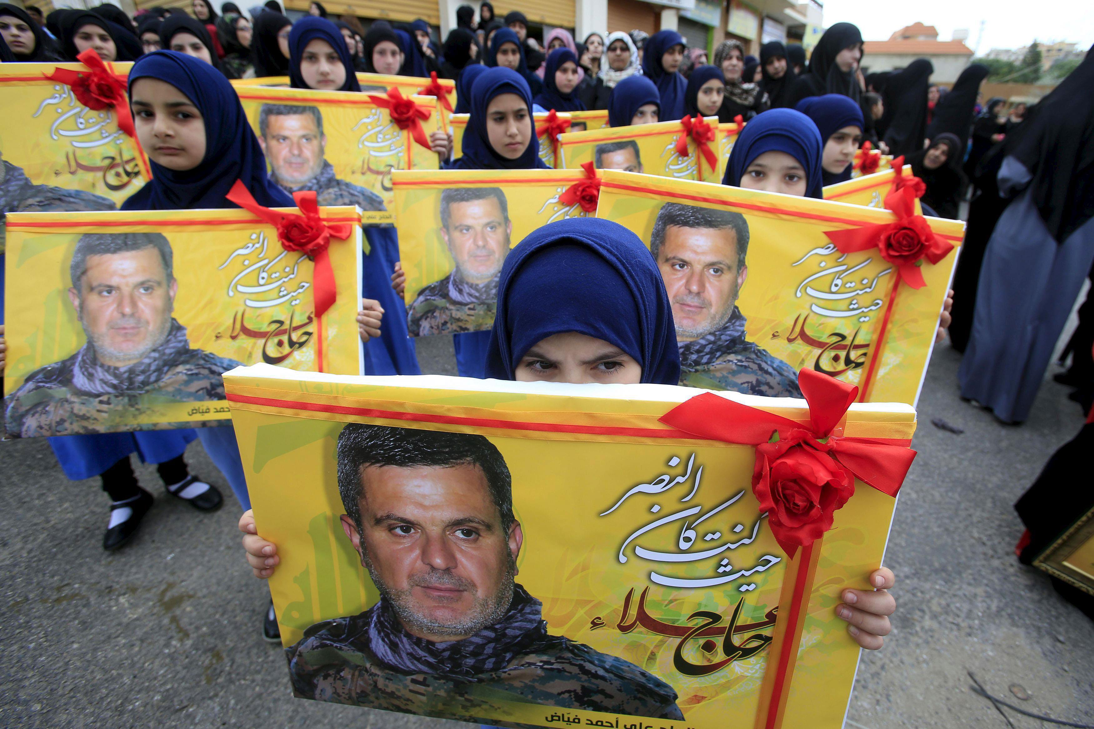 Lebanon's Hezbollah al-Mahdi girl scouts carry pictures of Ali Fayyad, one of Hezbollah's senior com
