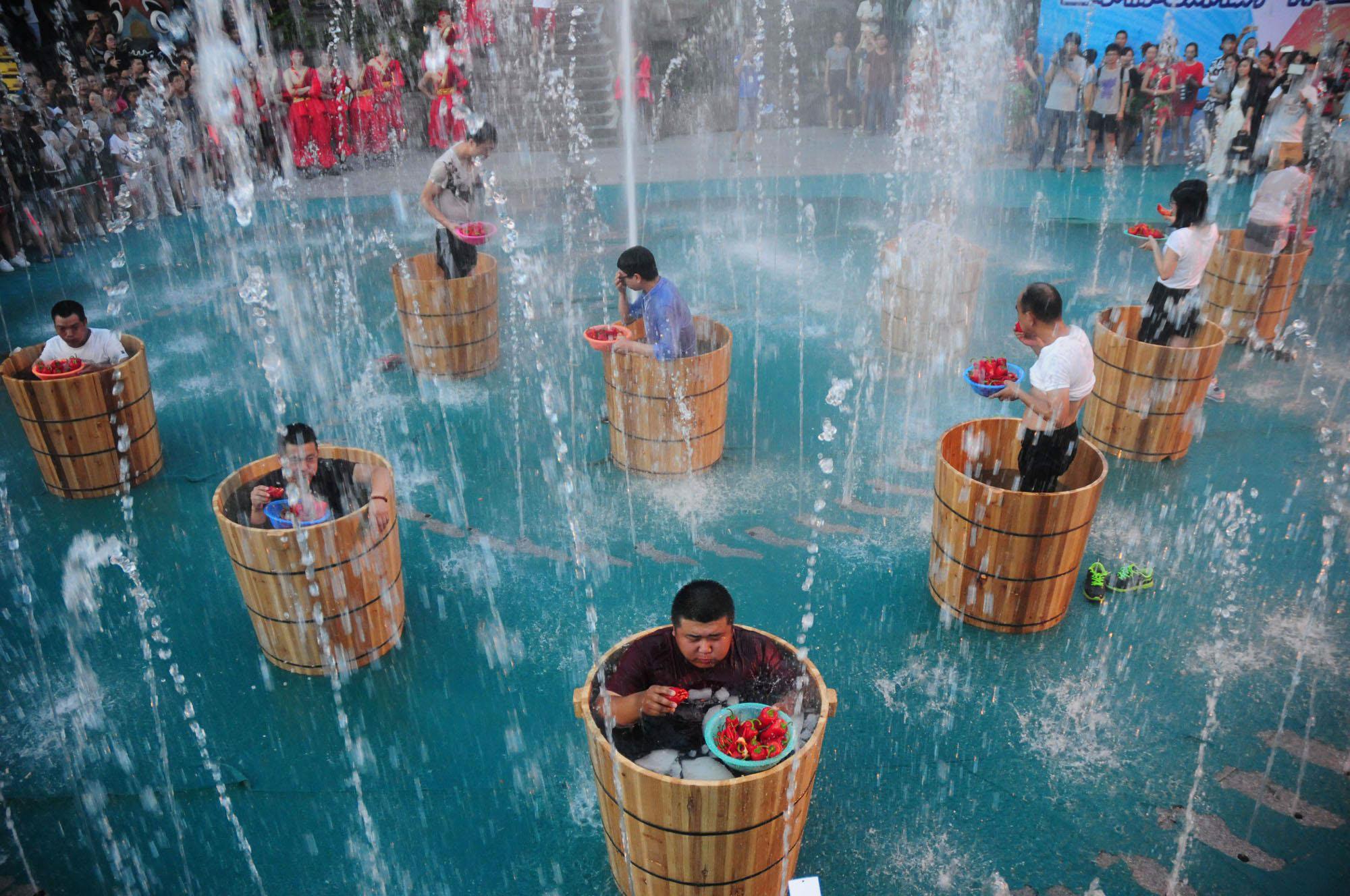 Participants eat chili as they bath in ice water during a chili eating competition in Hangzhou