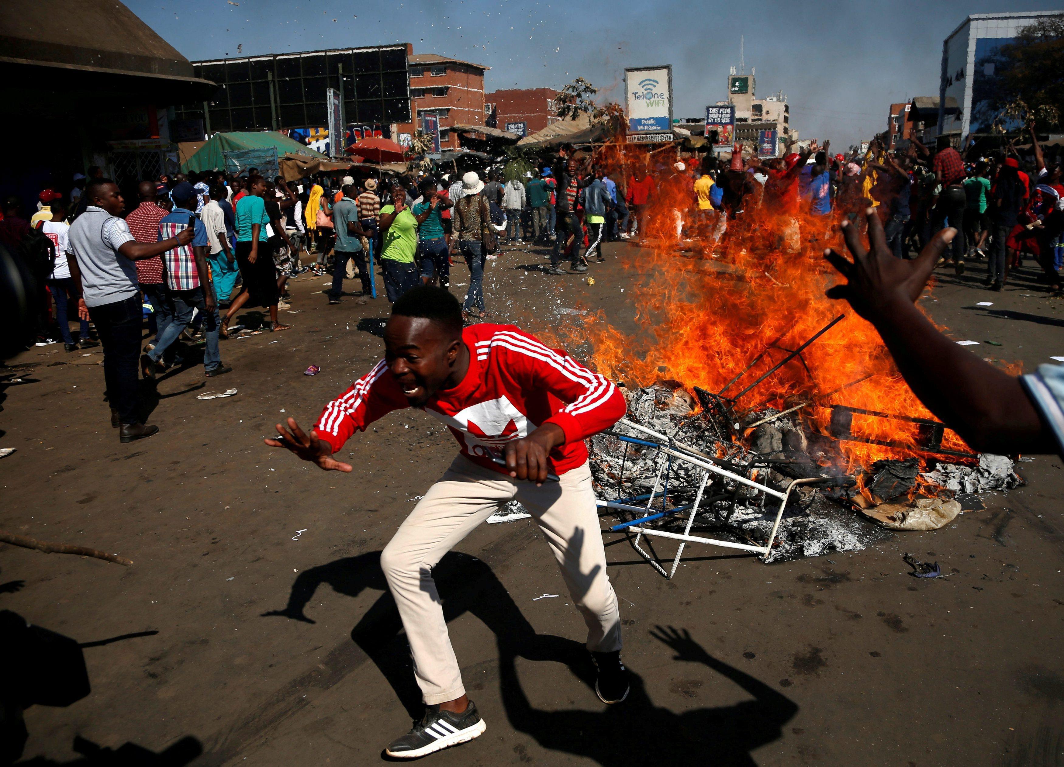 Supporters of opposition Chamisa's MDC party react as they block street in Harare