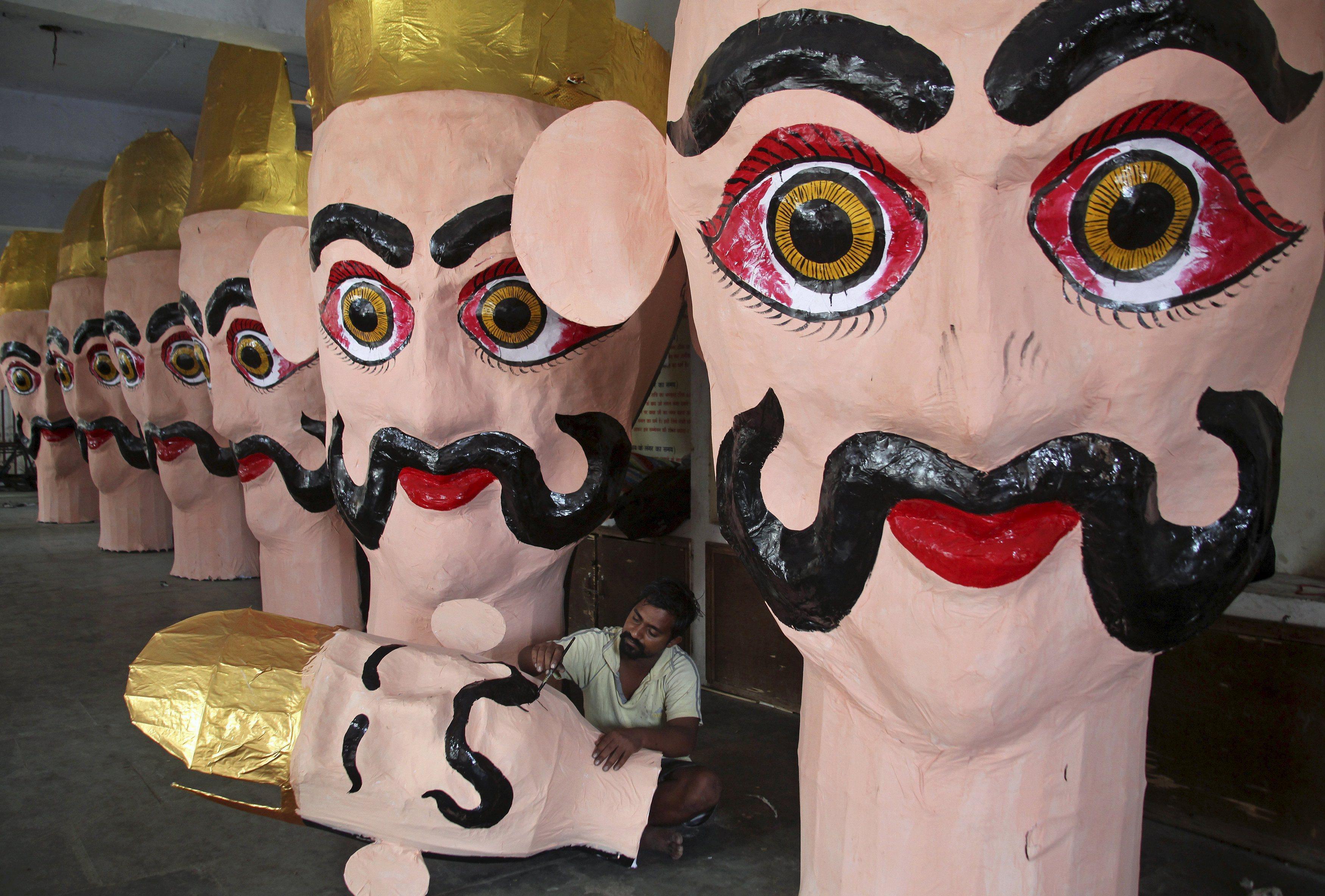 An artisan paints an effigy of demon king Ravana during preparation for the upcoming Hindu festival 