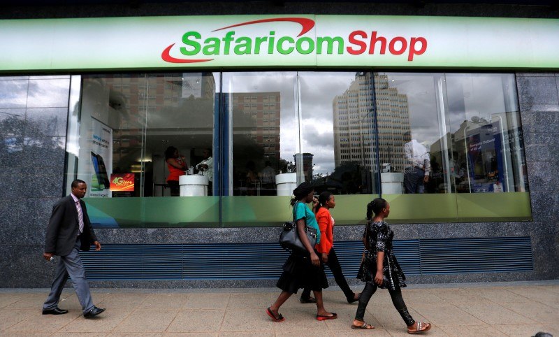 Pedestrians walk past a mobile phone care centre operated by Kenyan's telecom operator Safaricom in the central business district of Kenya's capital Nairobi, May 11, 2016. 