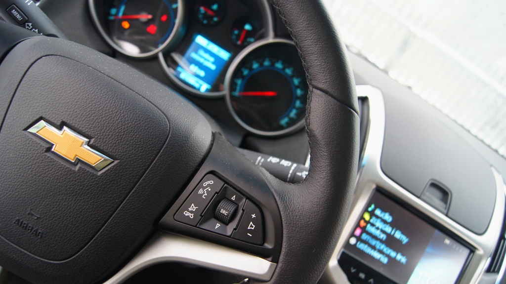 Wnętrze chevroleta cruze nie kusi polotem Alfy Romeo ale ujmuje praktycznością i bajerami. W testowanej przez nas wersji oko cieszyła posrebrzana, centralna konsola z multimedialnym systemem MultiLink (dostępny seryjnie w prezentowanej wersji LT+ oraz w LTZ). Wyposażony jest w on w dotykowy, tzw. rezystancyjny, ekran ciekłokrystaliczny, który można obsługiwać także w zimowych rękawiczkach