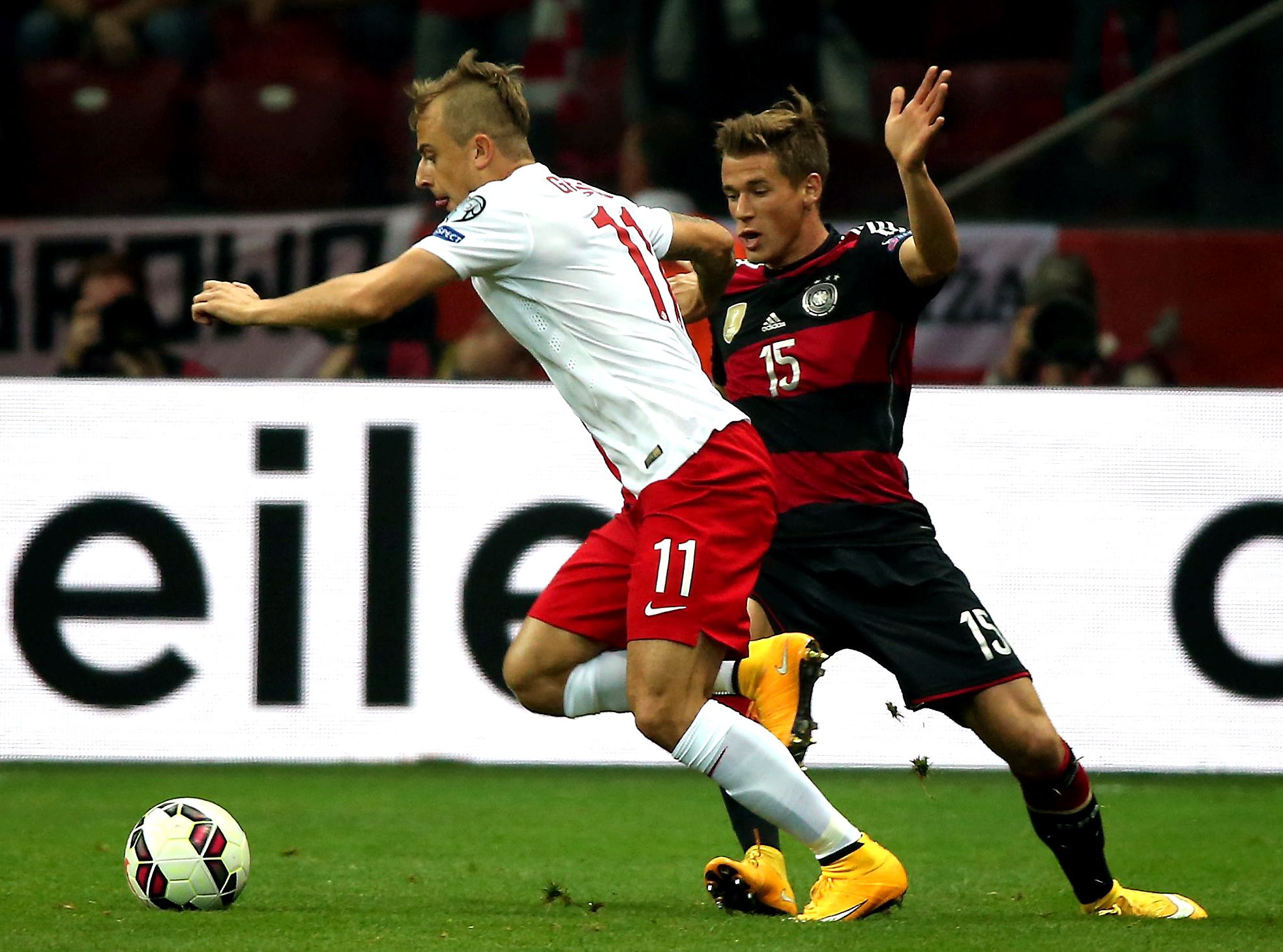 Polak Kamil Grosicki (L) walczy o piłkę z Niemcem Erikiem Durmem (P) podczas meczu eliminacyjnego mistrzostw Europy w Warszawie