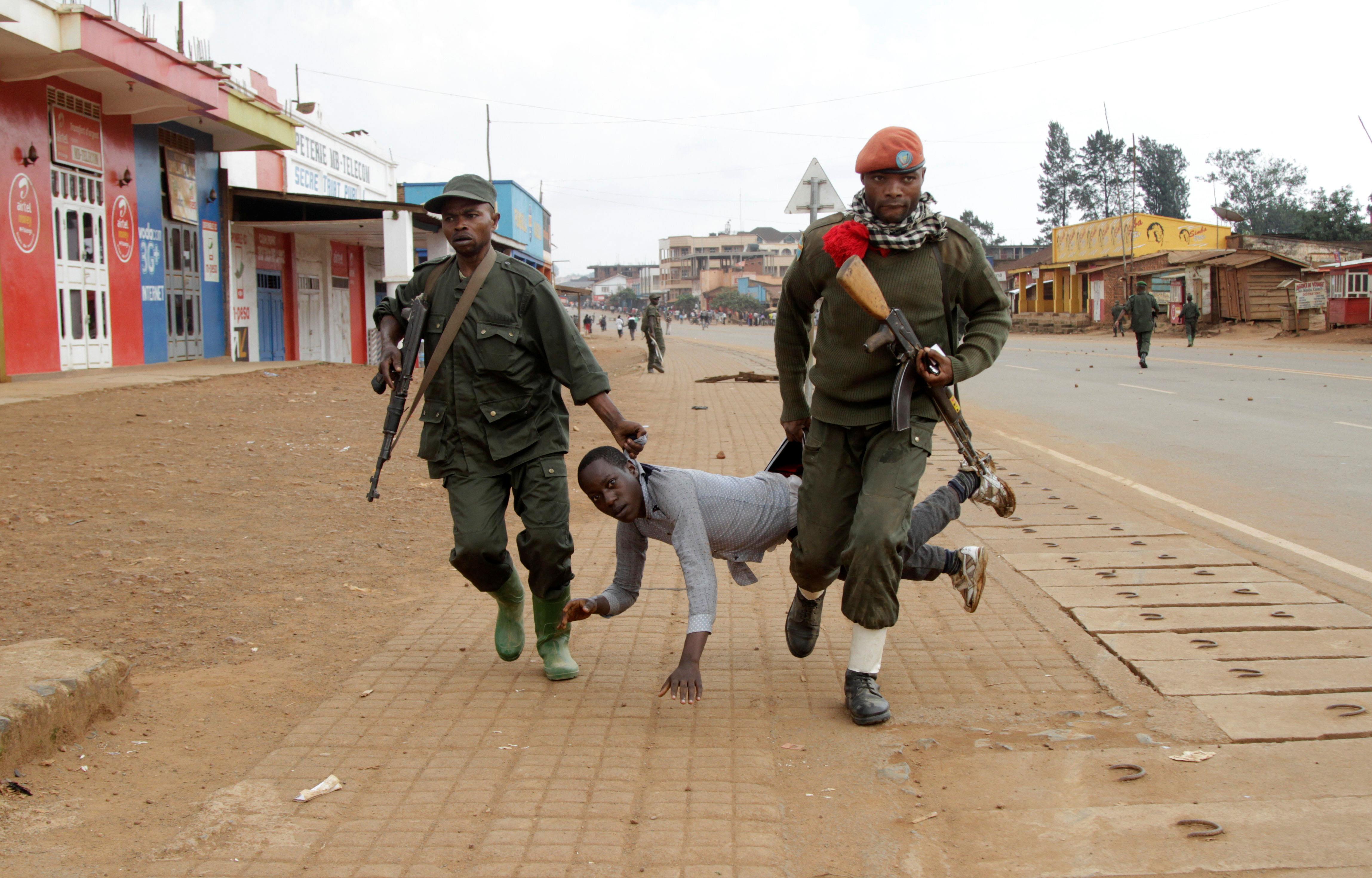 Congolese soldiers arrest a civilian protesting against the government's failure to stop the killing