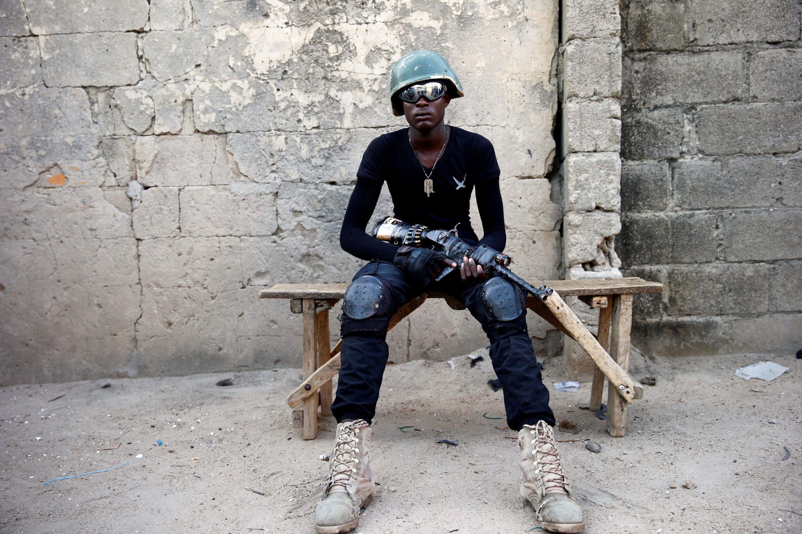 A member of the local militia group, otherwise known as CJTF, Adamu Mohammed, 23, poses for a portra