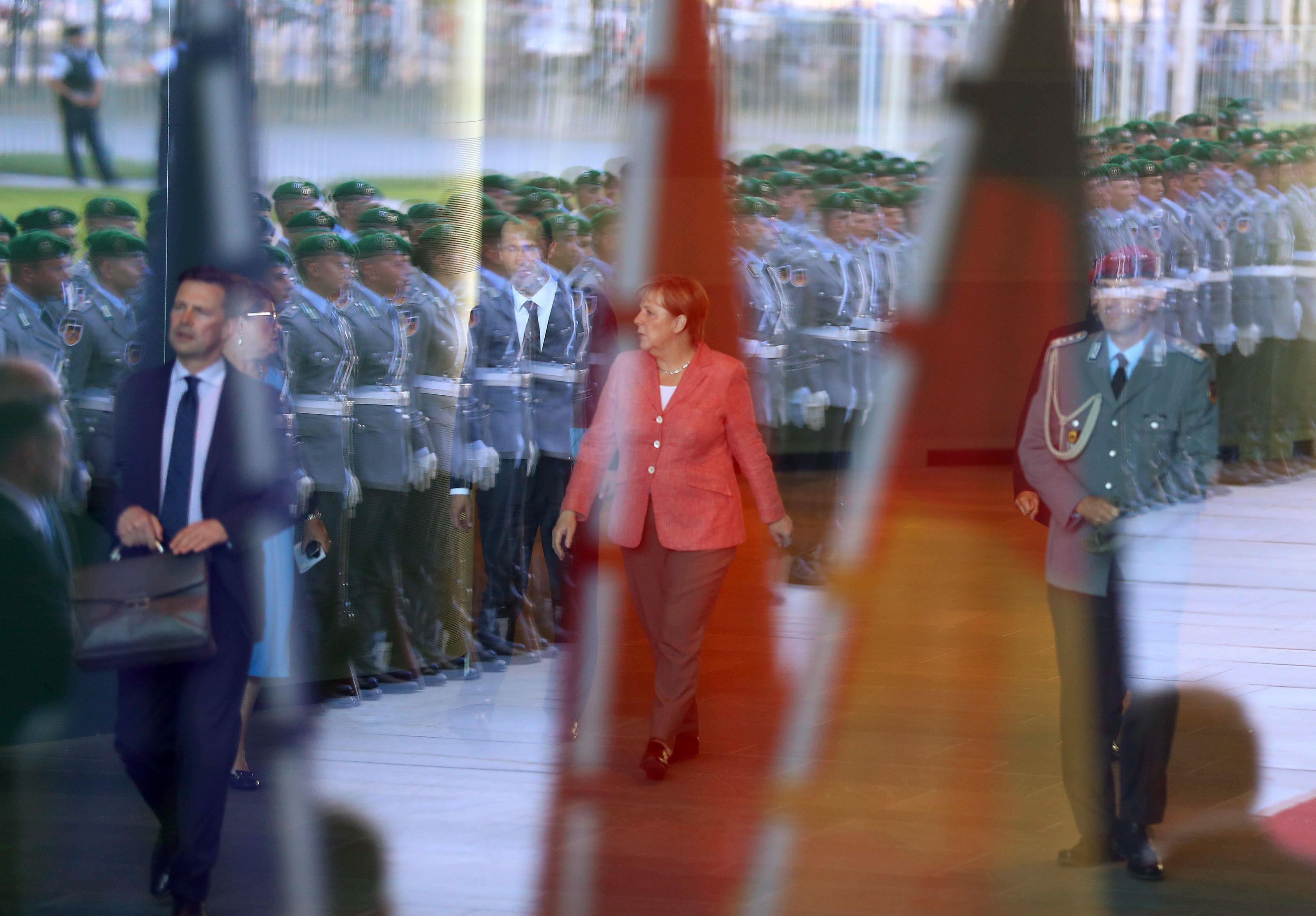 German Chancellor Angela Merkel awaits the arrival of Chinese Premier Li Keqiang before a welcome ce