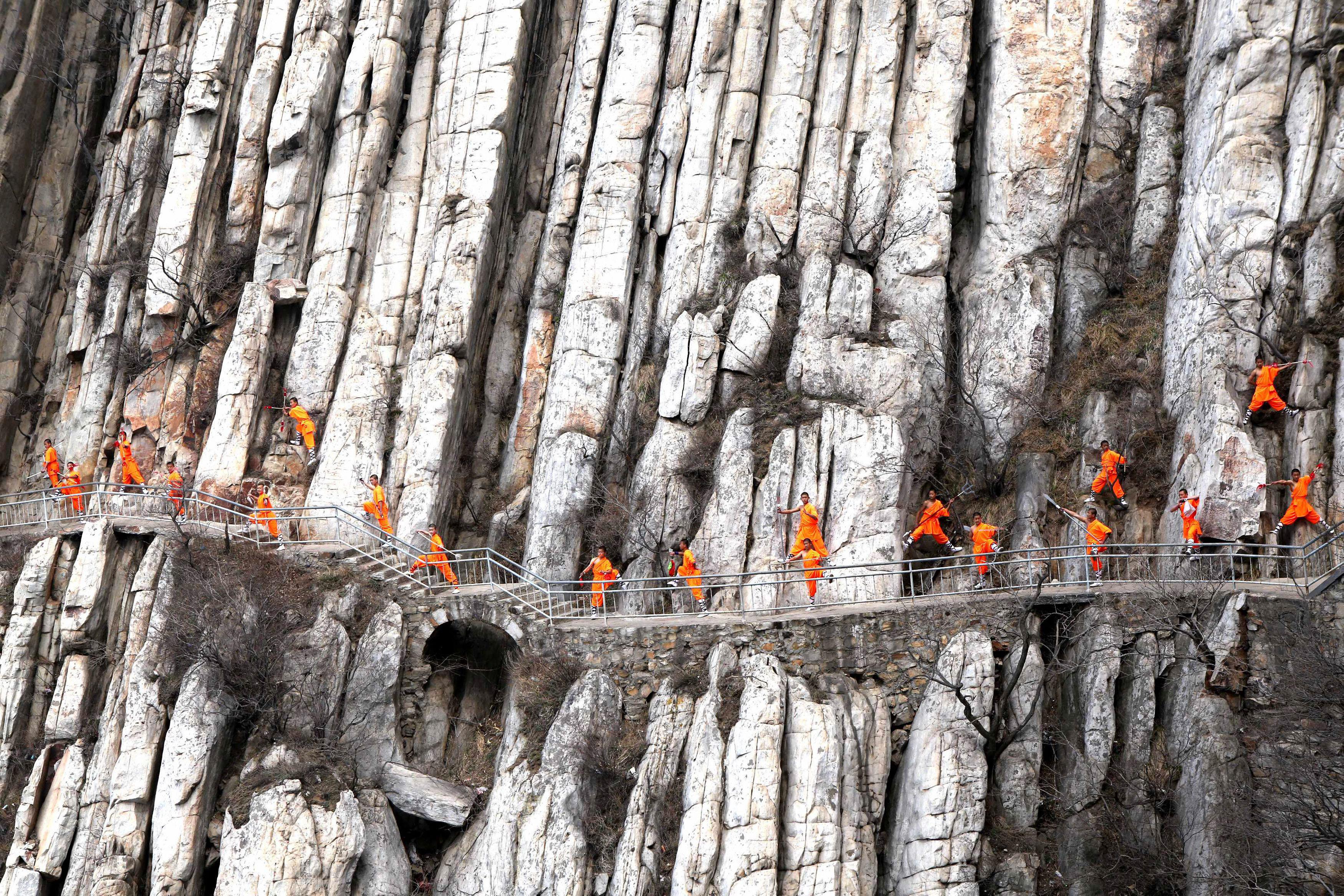 Students from a martial arts school practice Shaolin Kung Fu on cliffs in Dengfeng