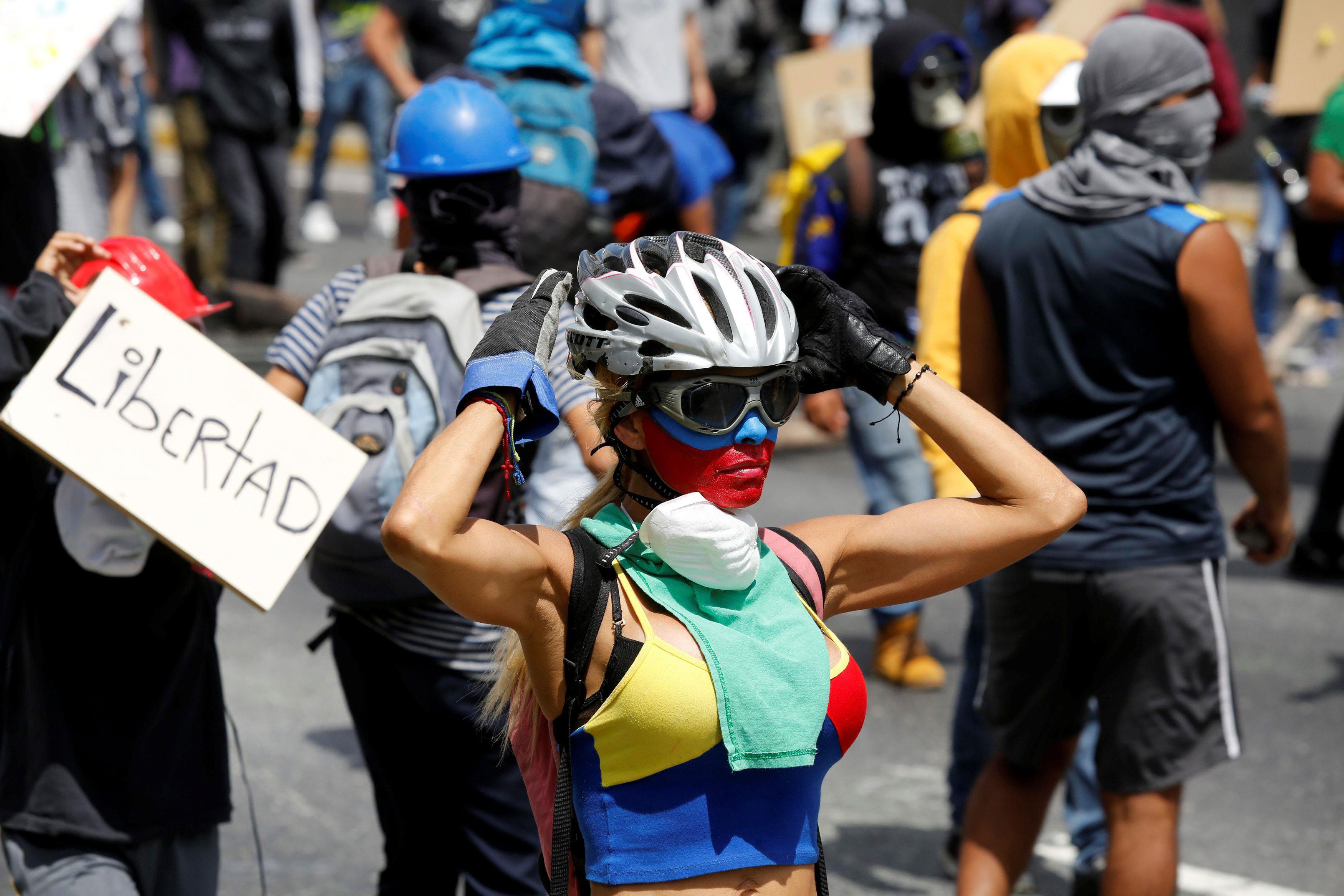 Opposition supporters rally against President Nicolas Maduro carrying a sign that reads 
