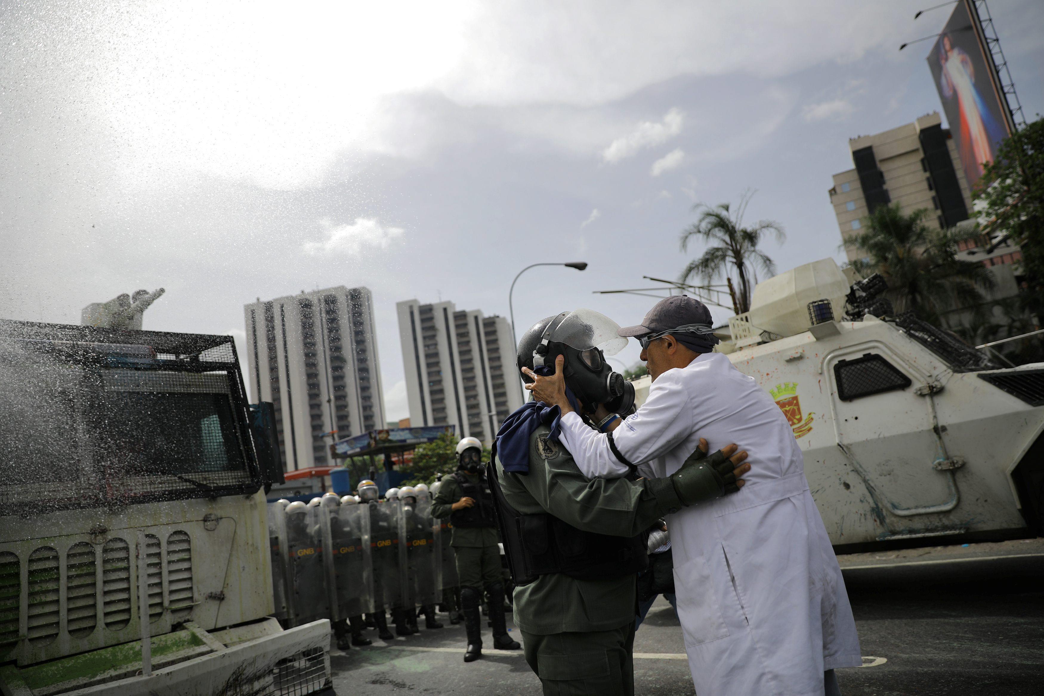 A demonstrator talks with a member of the Venezuelan National Guard during riots at a rally called b