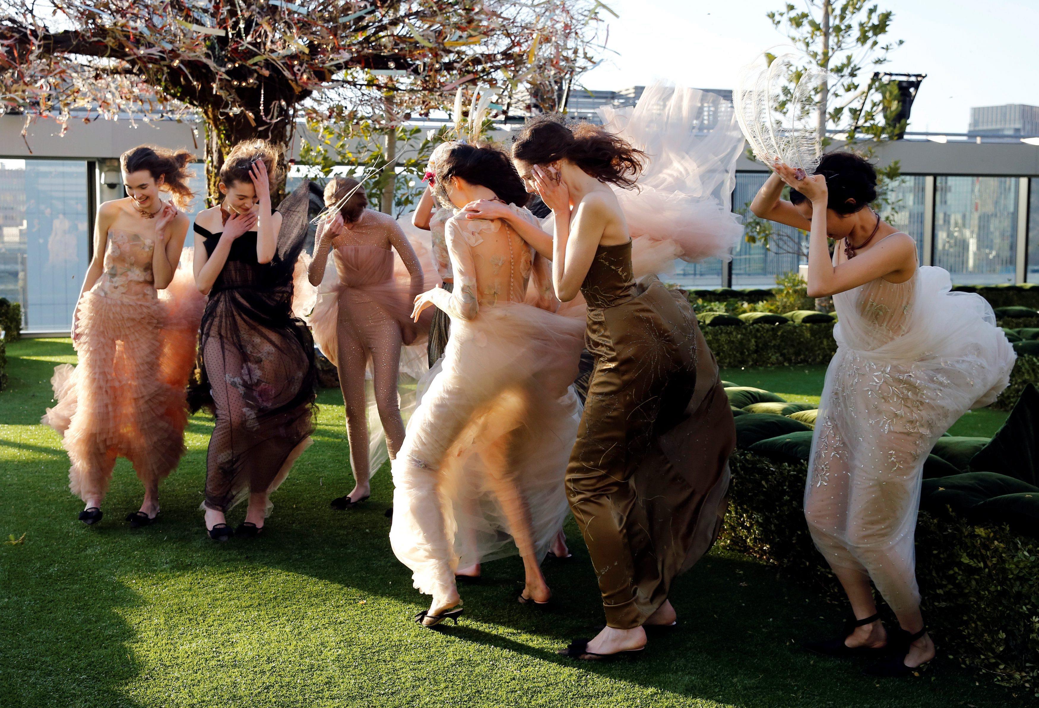 Models struggle against strong wind before the rehearsal of Christian Dior's Haute Couture Spring-Su