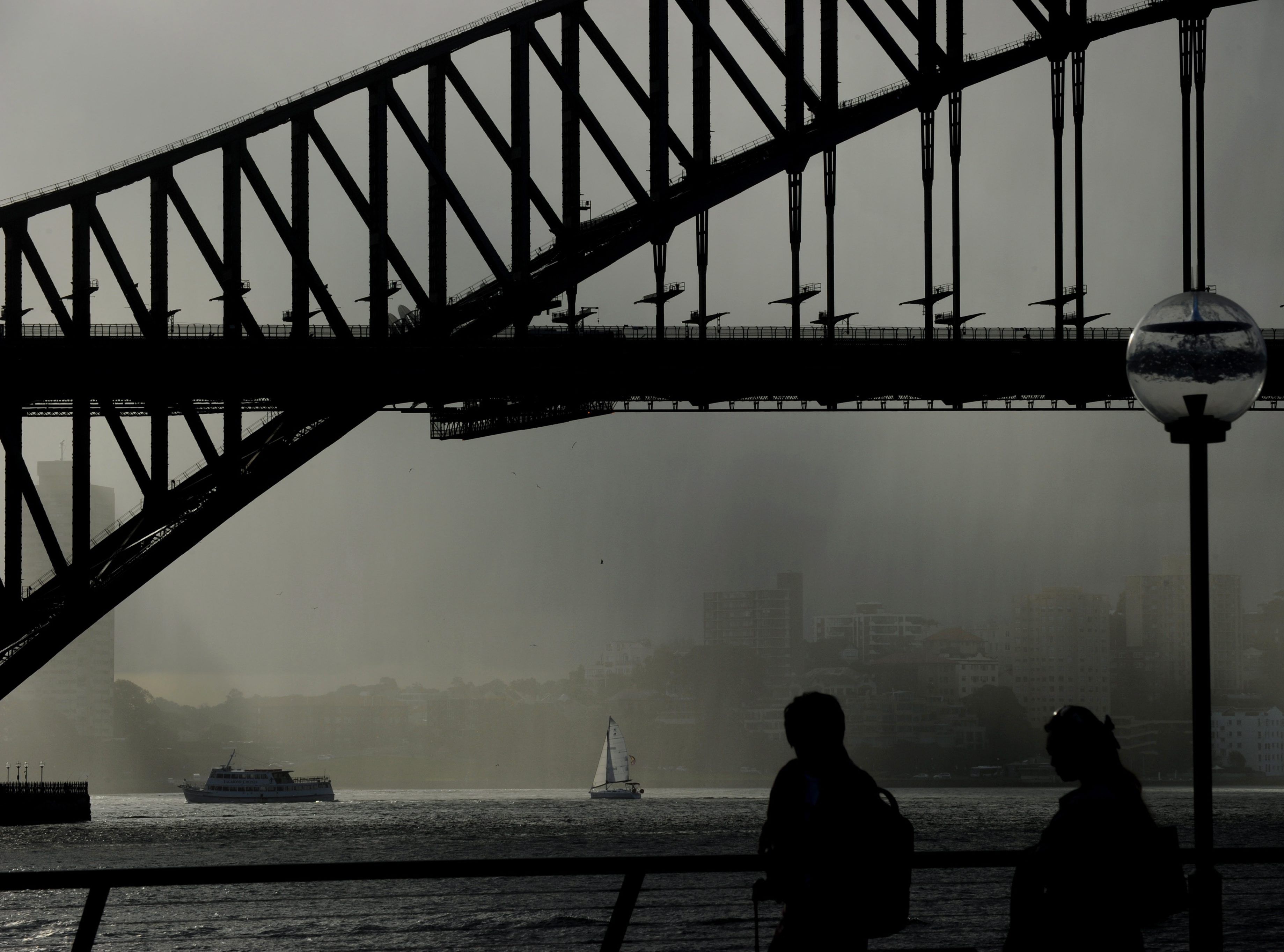 Słońce próbuje się przebić przez deszcz w okolicach słynnego Mostu Portowego w Sydney w Australii