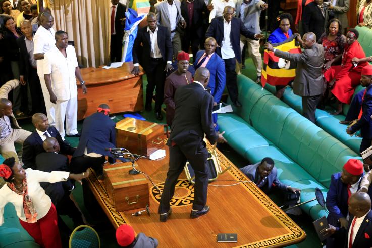Ugandan opposition lawmakers fight with plain-clothes security personnel in the parliament while protesting a proposed age limit amendment bill debate to change the constitution for the extension of the president's rule, in Kampala, Uganda September 27, 2017. (REUTERS/James Akena)