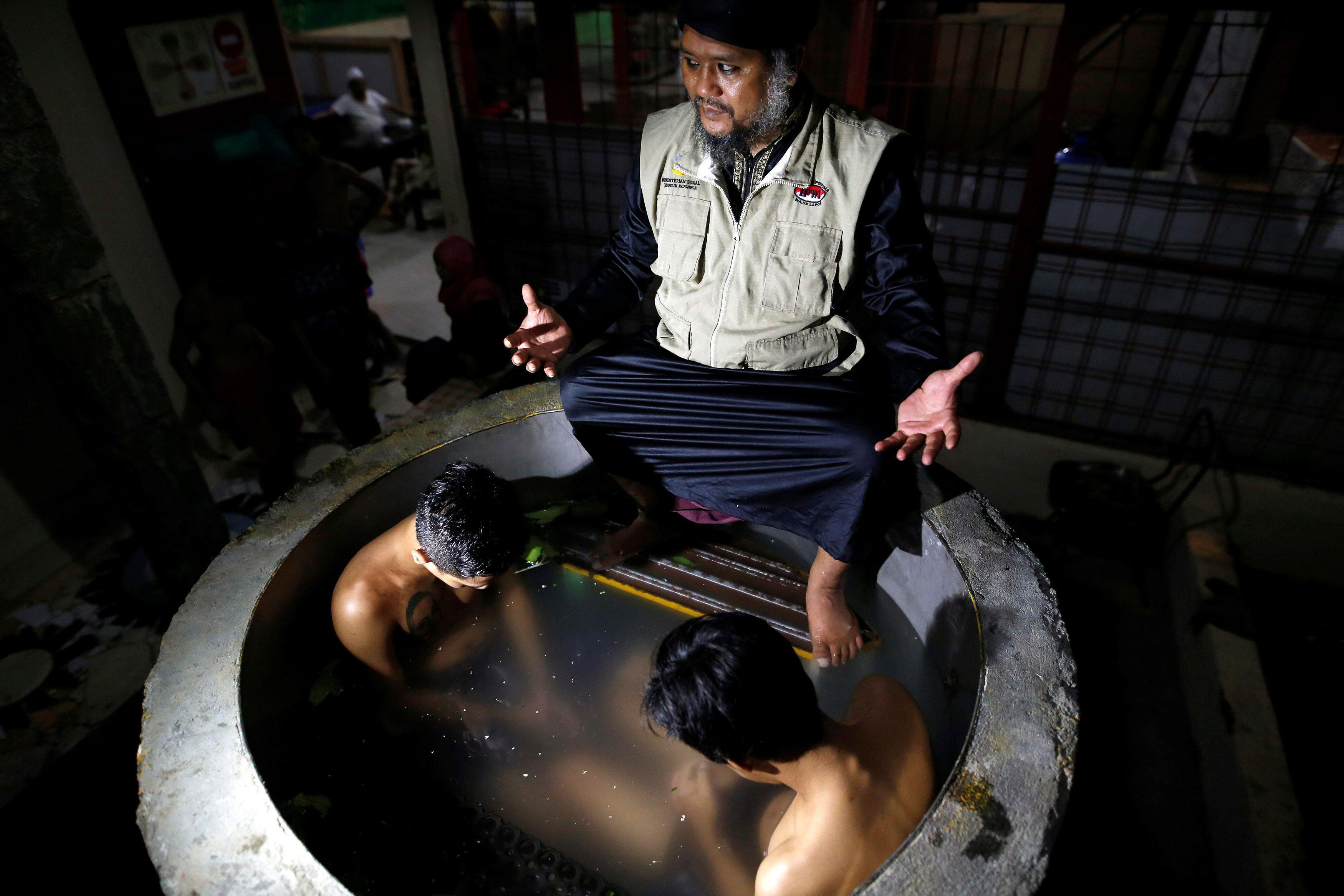 The head of a traditional drug addiction treatment center, Ustad Ahmad Ischsan Maulana, prays with t