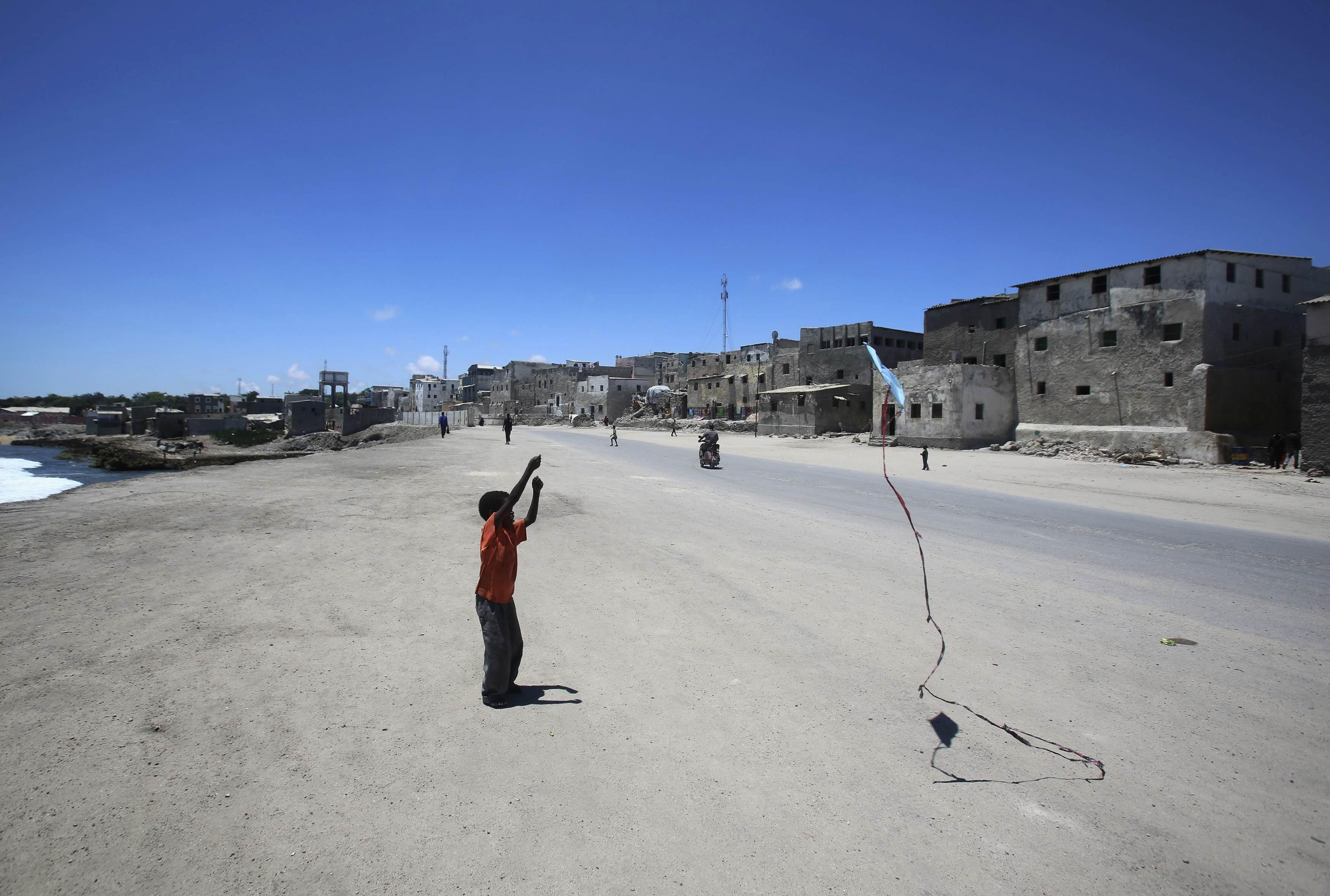 A boy plays with a kite in front of his home in the Hamaerweyne area of Mogadishu October 12, 2013. 