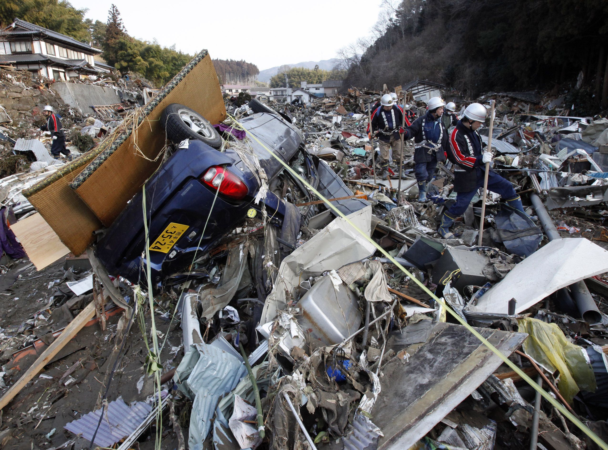 Strażacy ochotnicy szukają ofiar trzęsienia ziemi i tsunami w Rikuzentakada w prefekturze Iwate