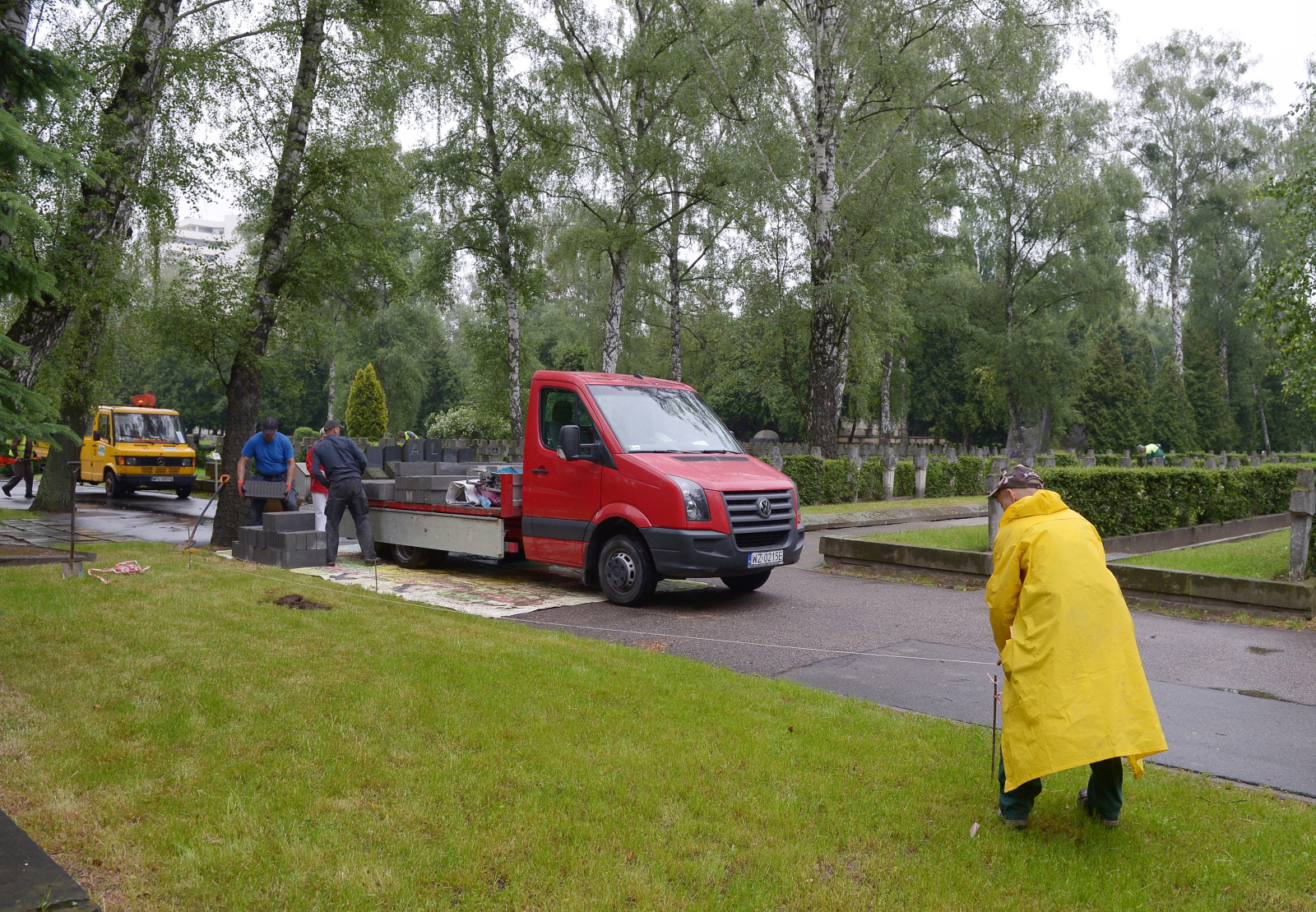 Trwają przygotowania do pogrzebu - pracownicy miejskich służb ustawiają taśmy odgradzające na trawnikach, przycinają krzewy, porządkują okolicę