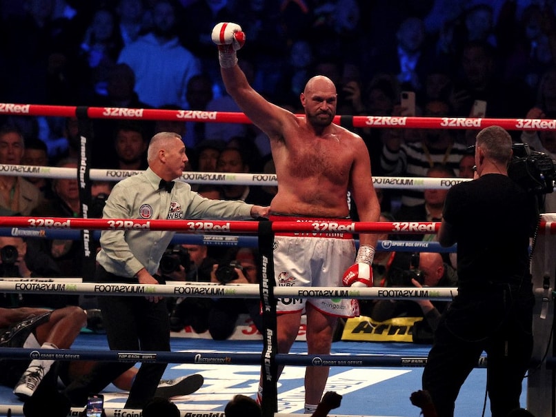Tyson Fury, arms raised in victory, makes successful defence of his WBC heavyweight title