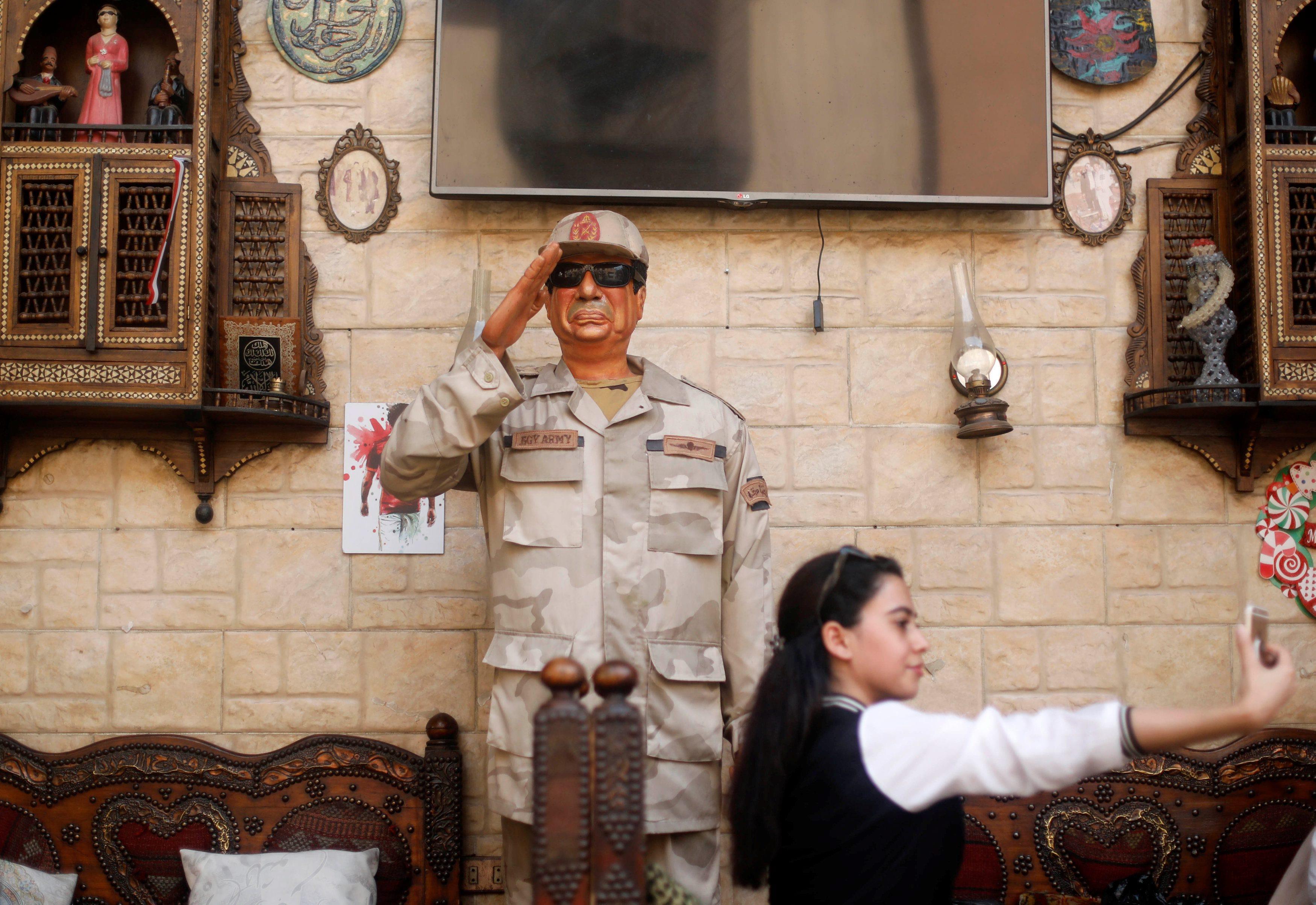 Woman takes a selfie with an effigy depicting Egyptian President Abdel Fattah al-Sisi during the sec