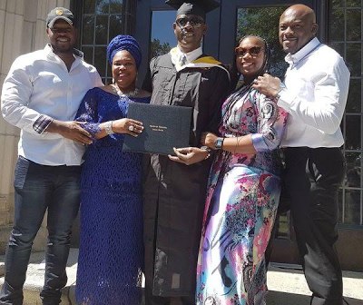 Musiliu Obanikoro flanked by his wife and children at his graduation