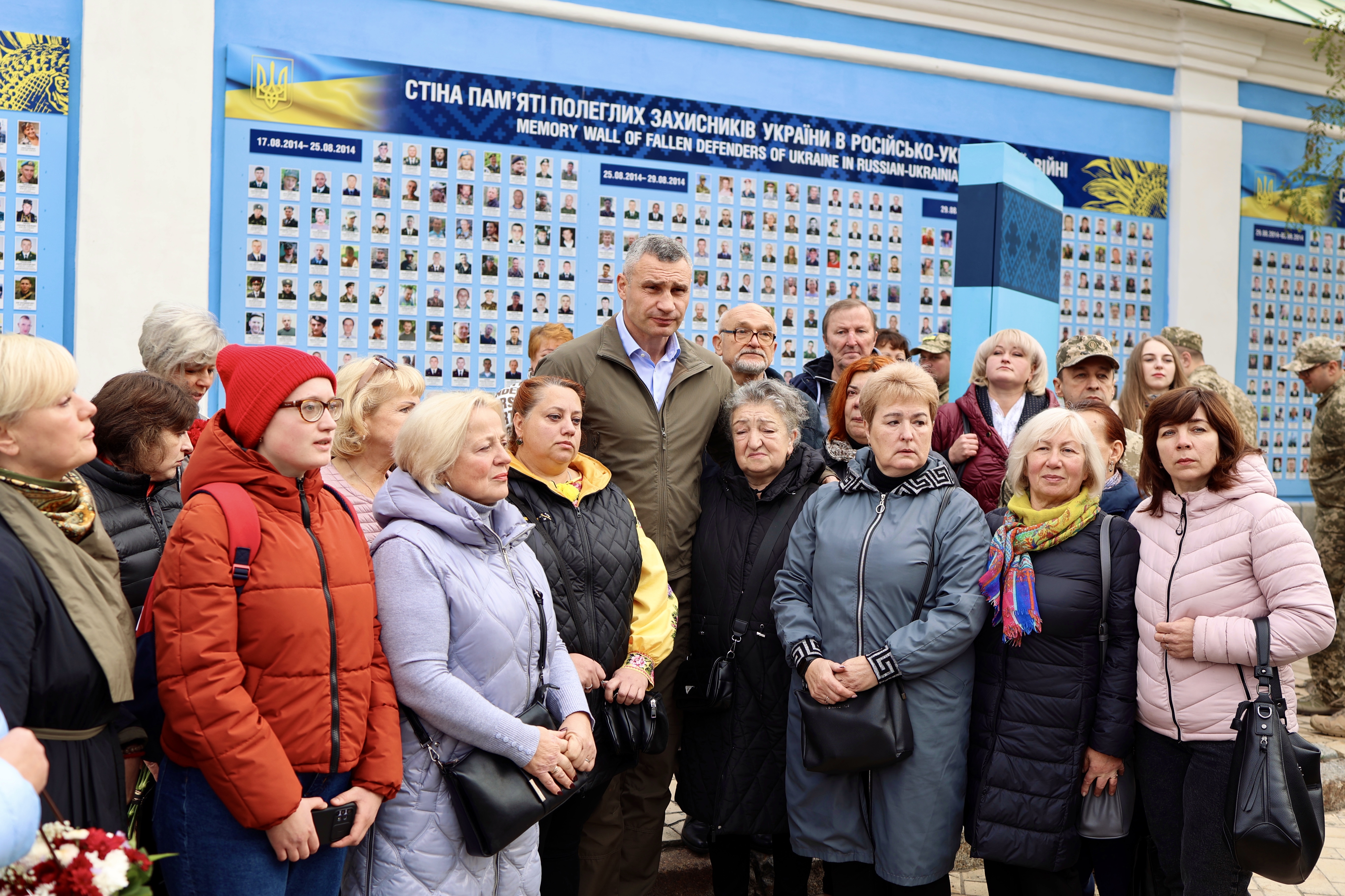 Mer Kijowa Witalij Kliczko pod ścianą pamięci z matkami i żonami poległych żołnierzy.