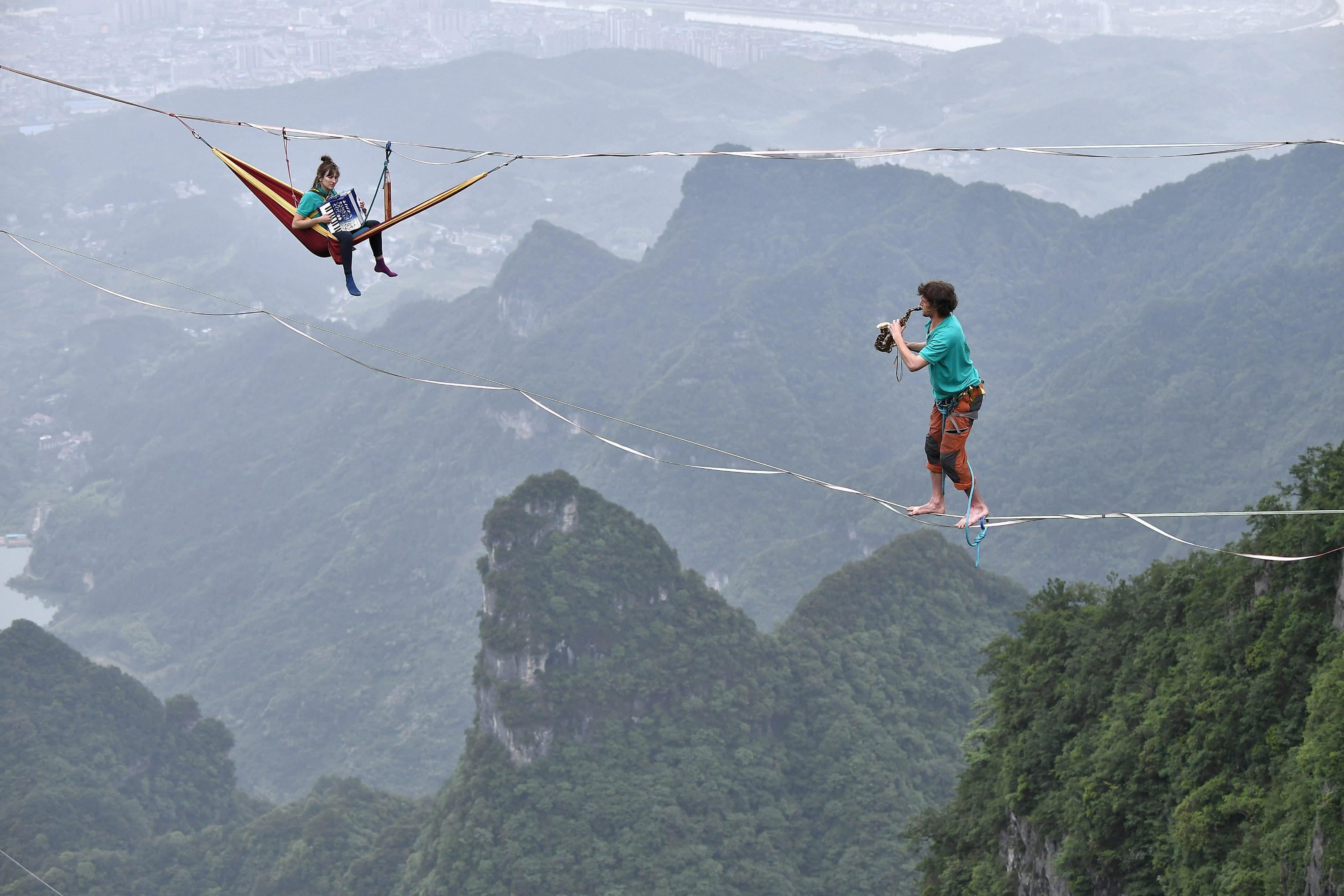 Members of performing group Houle Douce practise their instruments on tightropes ahead of a performa