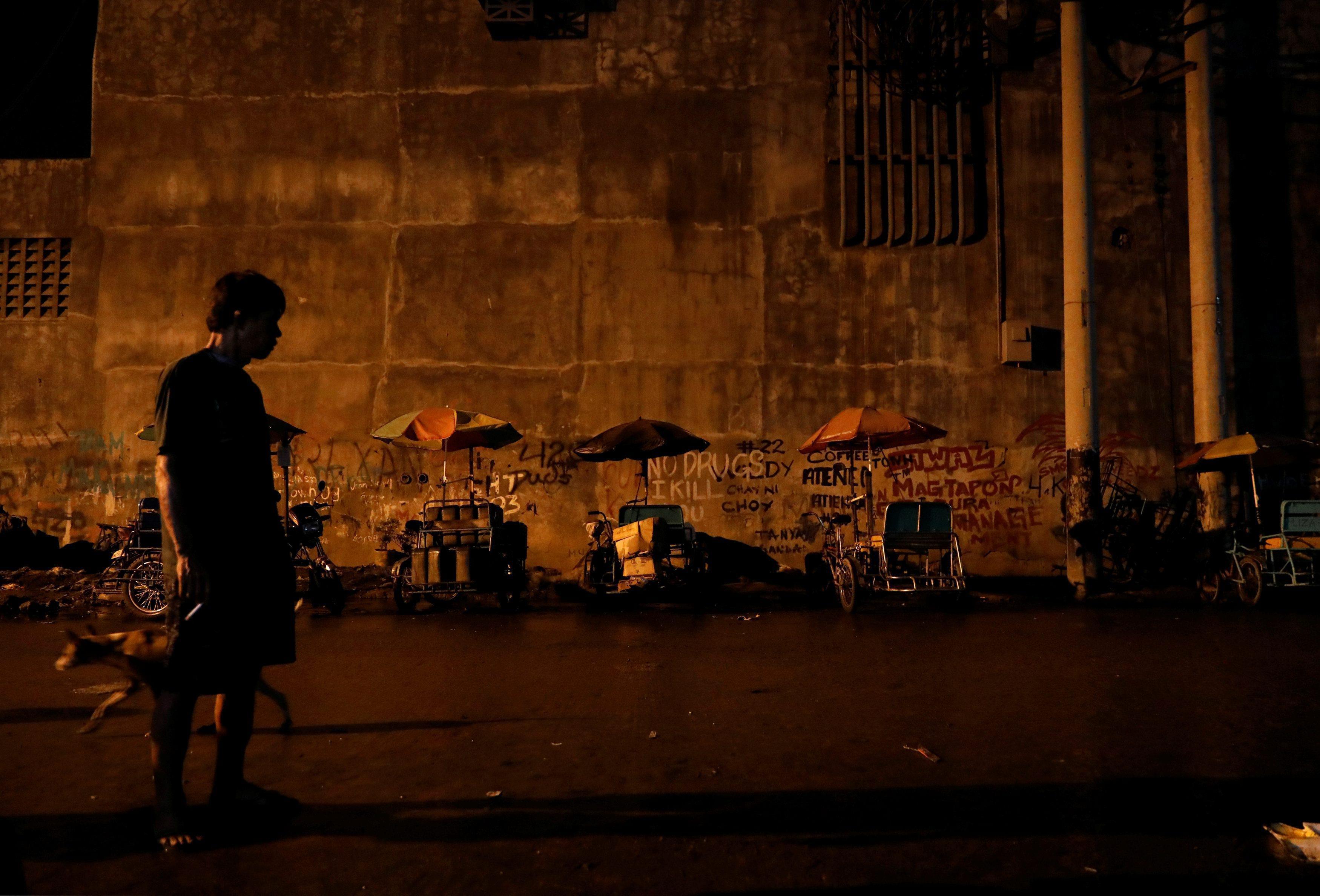 The Wider Image: Night in Manila slum revives spectre of drug war deaths