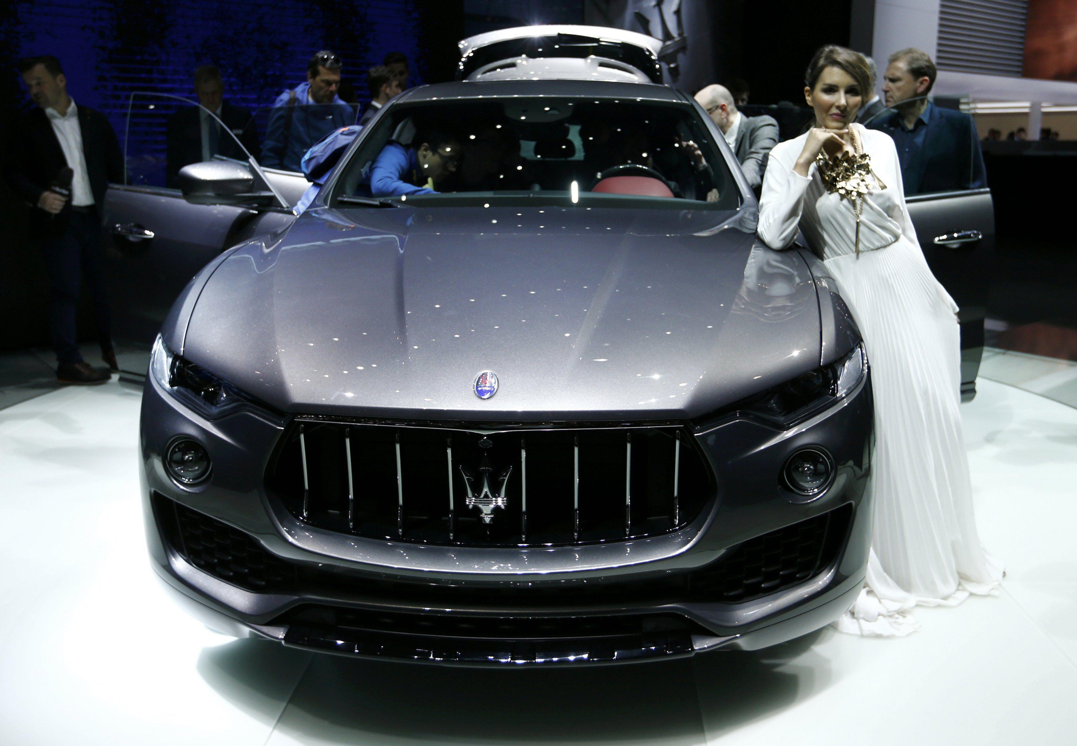 A model leans on a Maserati Levante SUV car at the 86th International Motor Show in Geneva