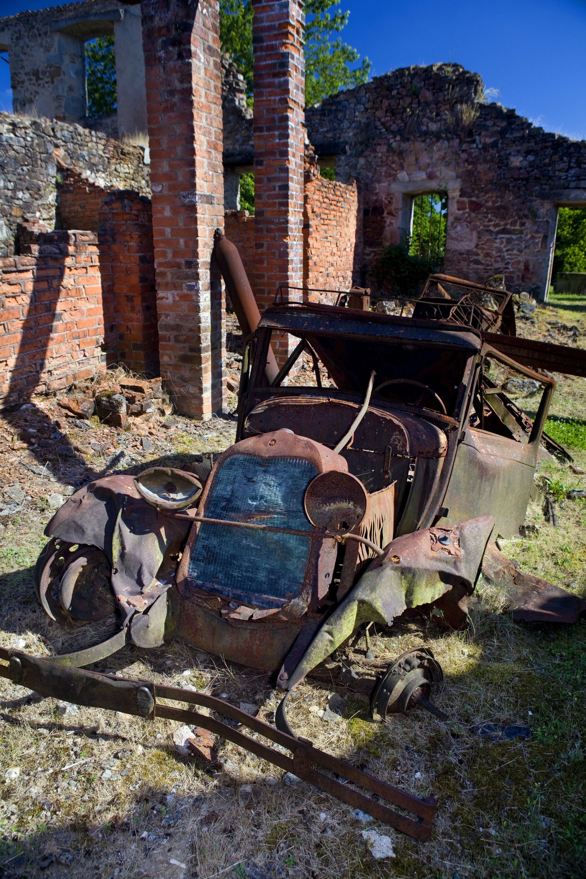 Tragedia rozegrała się <B>10 czerwca 1944 roku</B>. Oddziały SS w odwecie za zabicie przez francuski ruch oporu oficera SS weszły do miasteczka, wyganiając mieszkańców z domów i <B>rozstrzeliwując wszystkich bez wyjątku - mężczyzn, kobiety i dzieci</B>. <BR><BR> Tych, którzy nie zginęli od razu, Niemcy zapędzili do kościoła. Budynek <b>podpalili, wrzucali do środka granaty, strzelali do osób, które próbowały uciec</b>. Tego dnia wymordowali <b>642 mieszkańców miasteczka</b>. Przeżyła 47-letnia kobieta, której udało się wyskoczyć przez okienko w kościele i uciec, pięciu mężczyzn oraz jedno dziecko. <BR><BR> Jak się potem okazało, Niemcy wymierzyli tę okrutną karę mieszkańcom nie tego miasta, które planowali spacyfikować. W rzeczywistości oficer SS został zabity w <b>Oradour-sur-Vayres</b>. <BR><BR> Miasteczka nigdy nie odbudowano. Jego <b>ruiny zamieniono po wojnie w ogromne muzeum</b>. Wizyta w tym miejscu robi duże wrażenie. Na ulicach i podwórkach wciąż stoją <b>auta zabitych mieszkańców</B>, gdzieniegdzie pod ścianą domu widać oparty zardzewiały rower, można również zobaczyć część osobistych przedmiotów ofiar. <BR><BR> <b>Oradour-sur-Glane</B> to jedna z czterech miejscowości, jakie w czasie wojny spotkał taki los. W podobny sposób, mordując mieszkańców w zemście, Niemcy potraktowali również Lidice w Czechach, Mazinote we Włoszech oraz wieś Sochy na Lubelszczyźnie. Tragedię tej ostatniej opisała <b>Anna Janko w książce