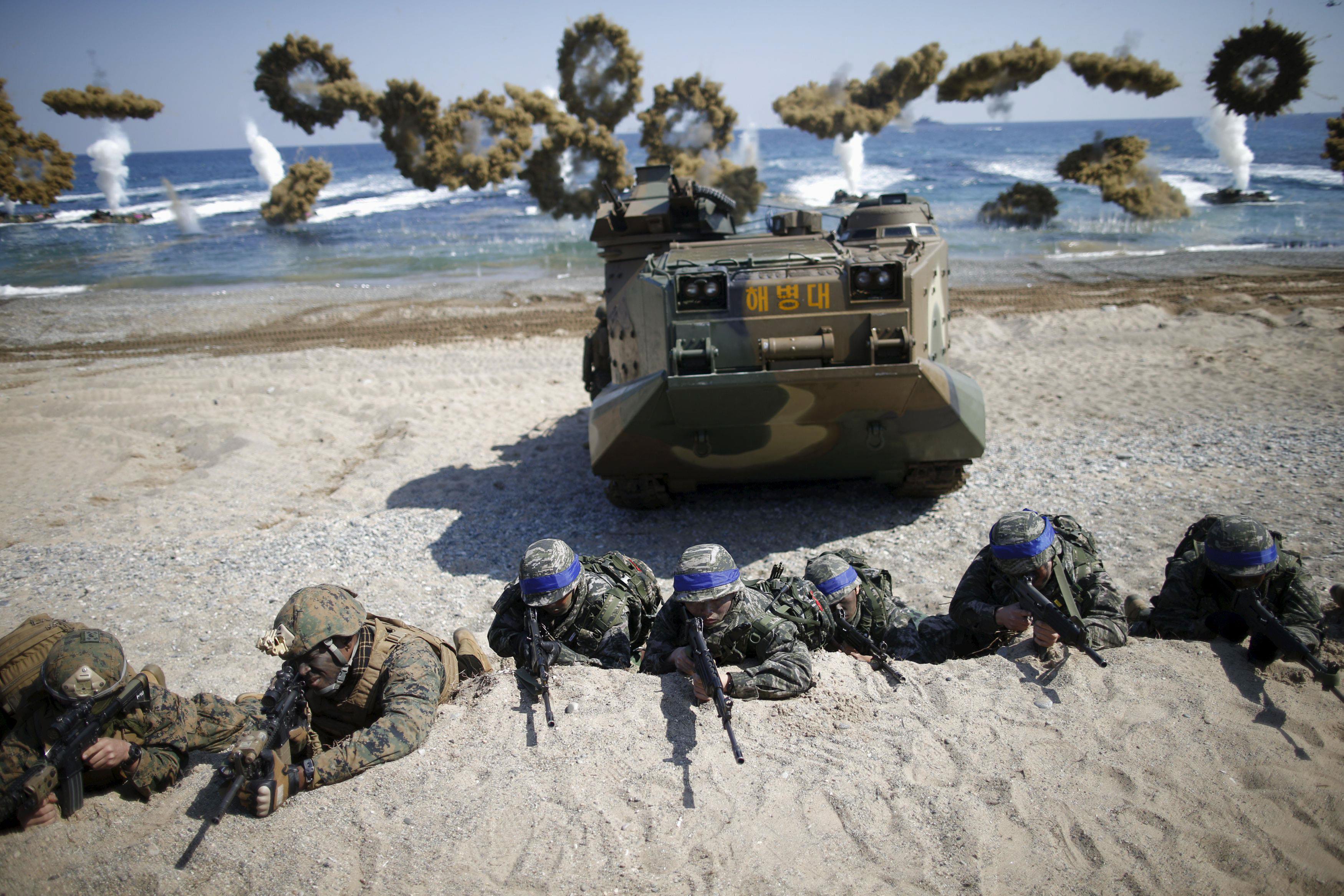 South Korean and U.S. Marines take positions as amphibious assault vehicles of the South Korean Mari