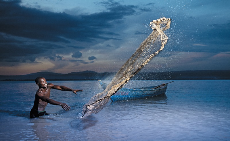 A fisherman in Lake victoria casting his net.