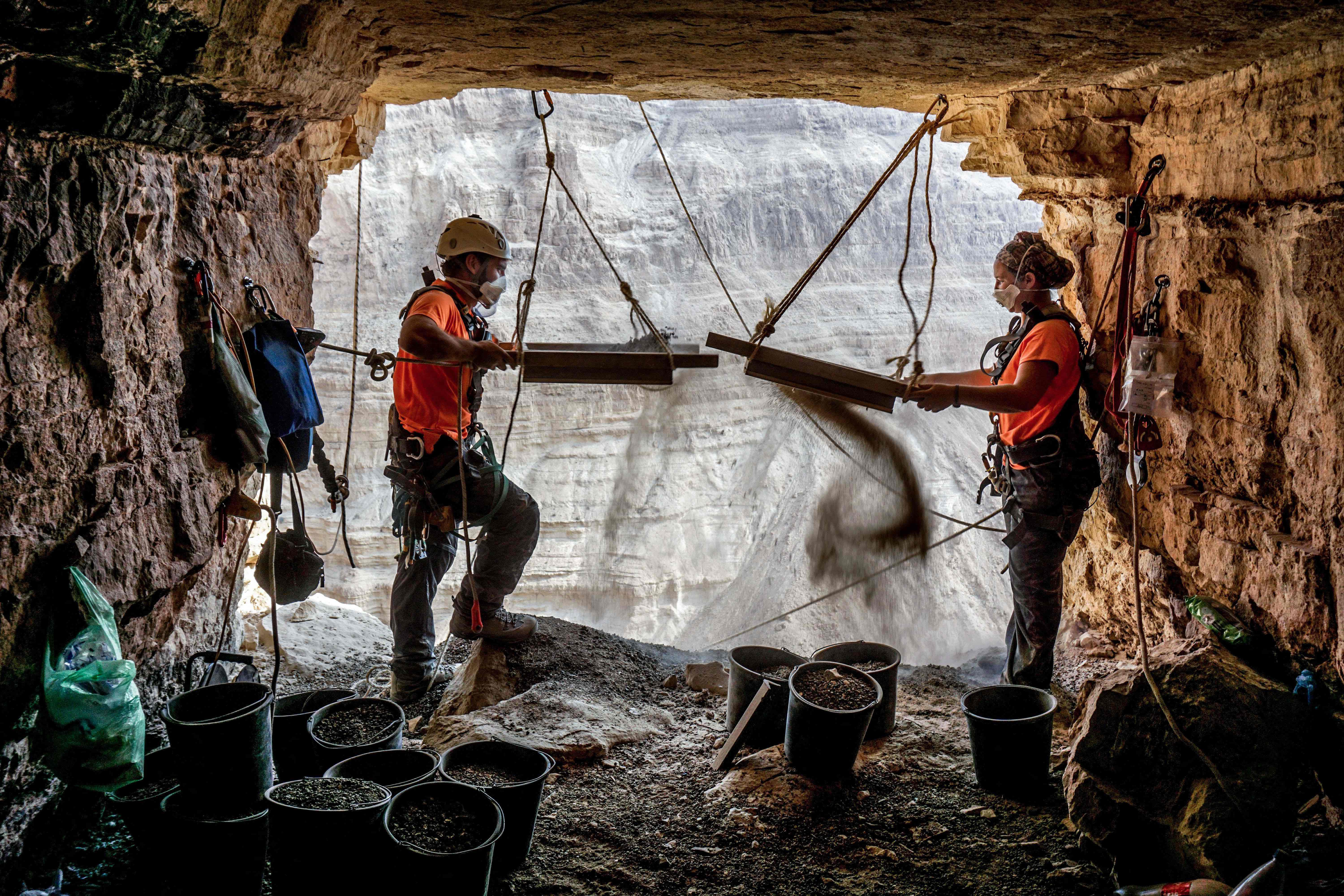 Archeolodzy Hagay Hamer i Oriah Amichai przesiewają ziemię podczas wykopalisk w Jaskini Grozy na Pustyni Judzkiej, marzec 2021 r. 